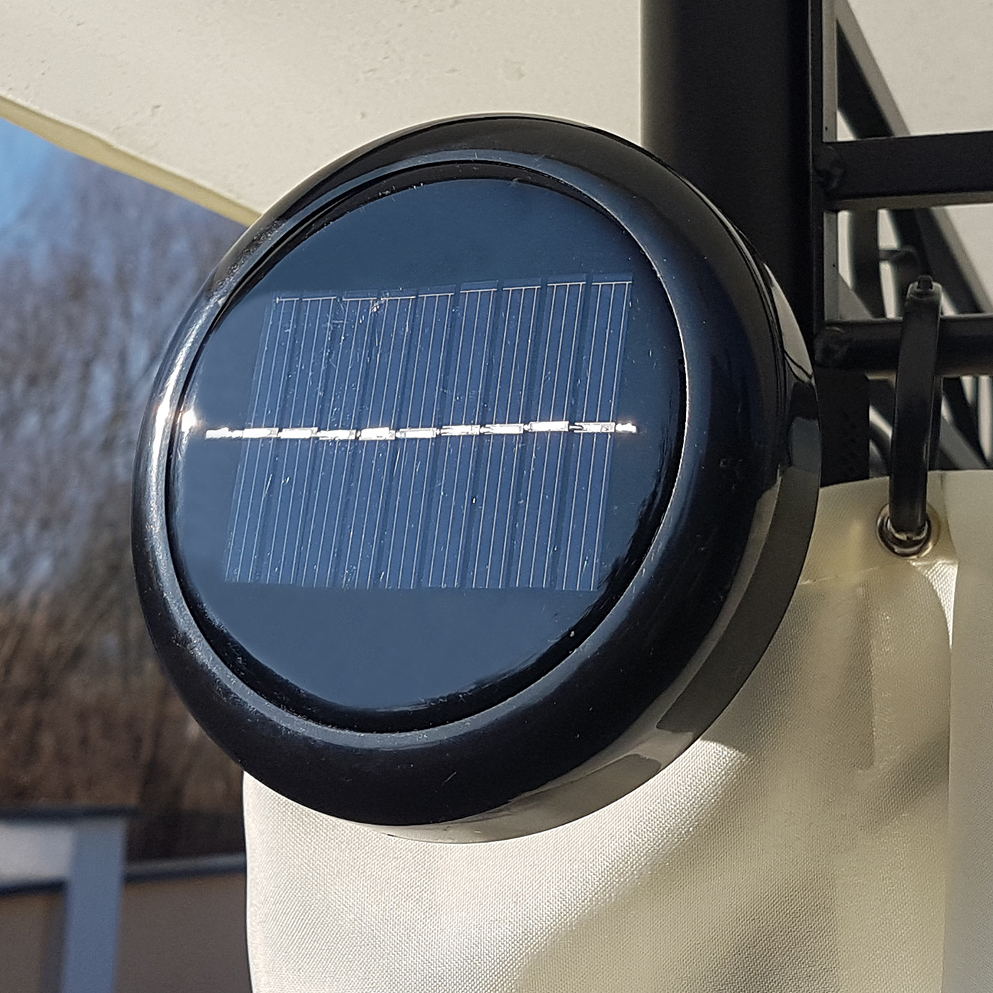 Rundes schwarzes Solarpanel. Montiert an einer gebogenen Struktur mit weißem Hintergrund.