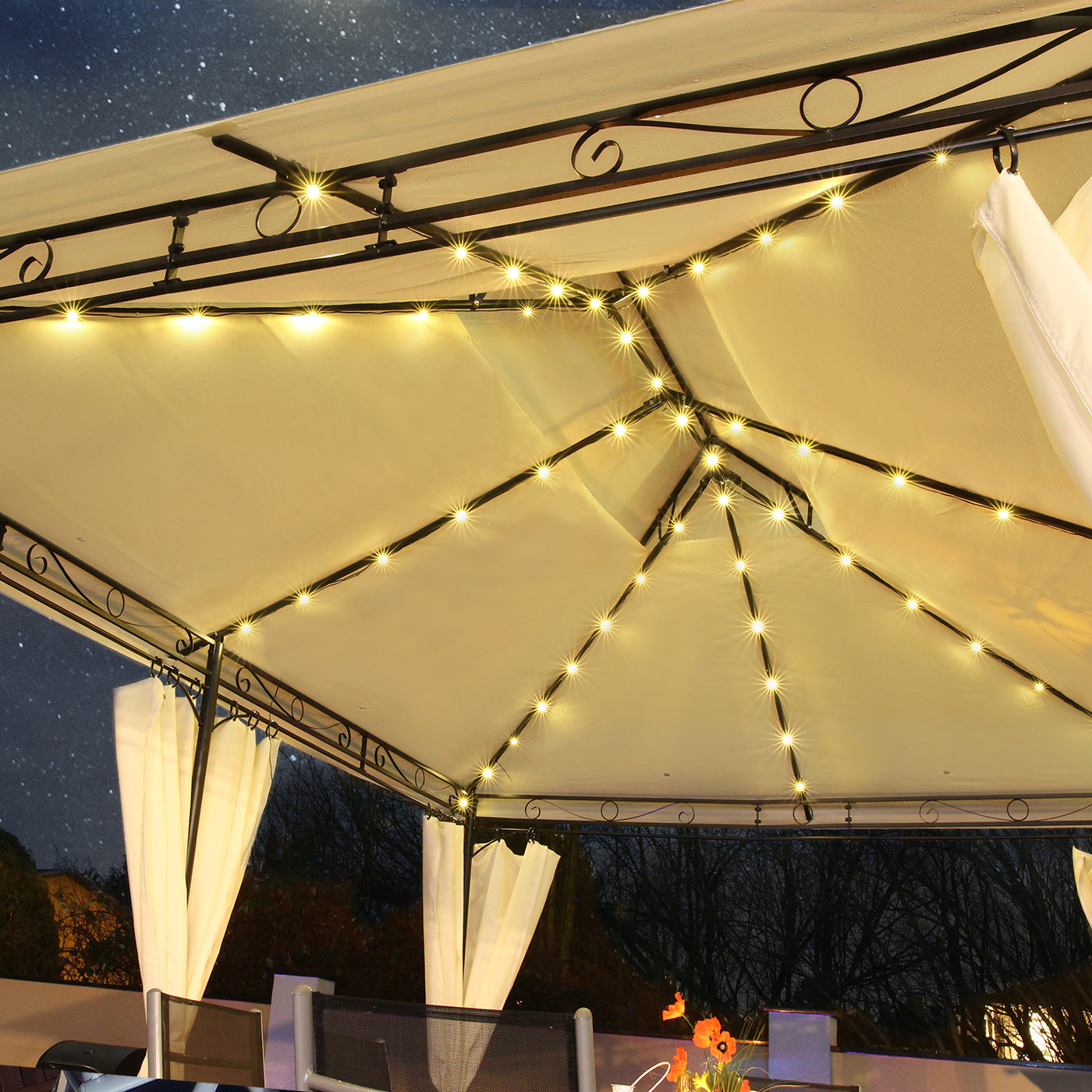 Pavillon mit Lichtern in einer sternenklaren Nacht. Weiße Vorhänge und dunkler Hintergrund.
