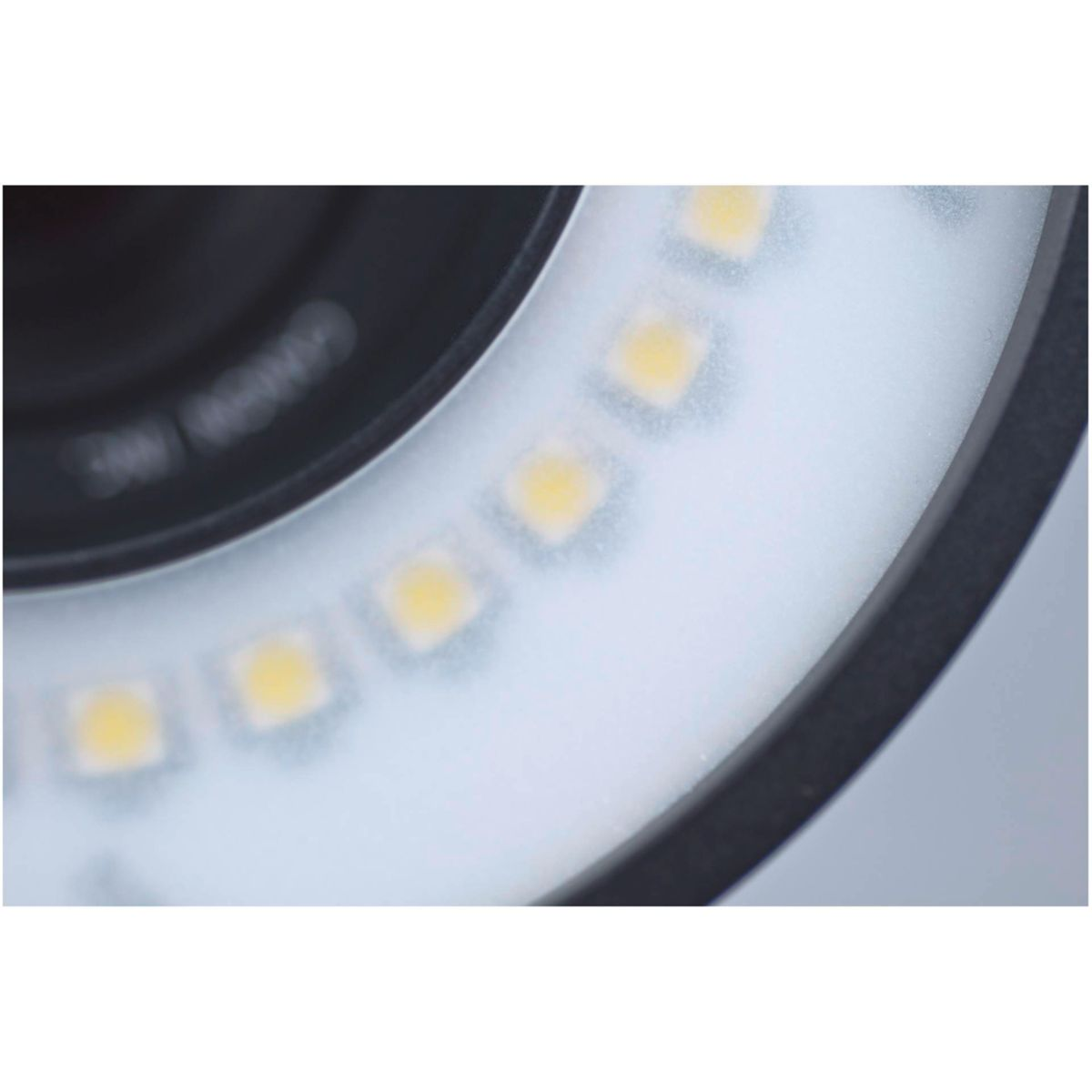 Nahaufnahme eines Ringlichts mit hellgelben LEDs um eine schwarze Linse.