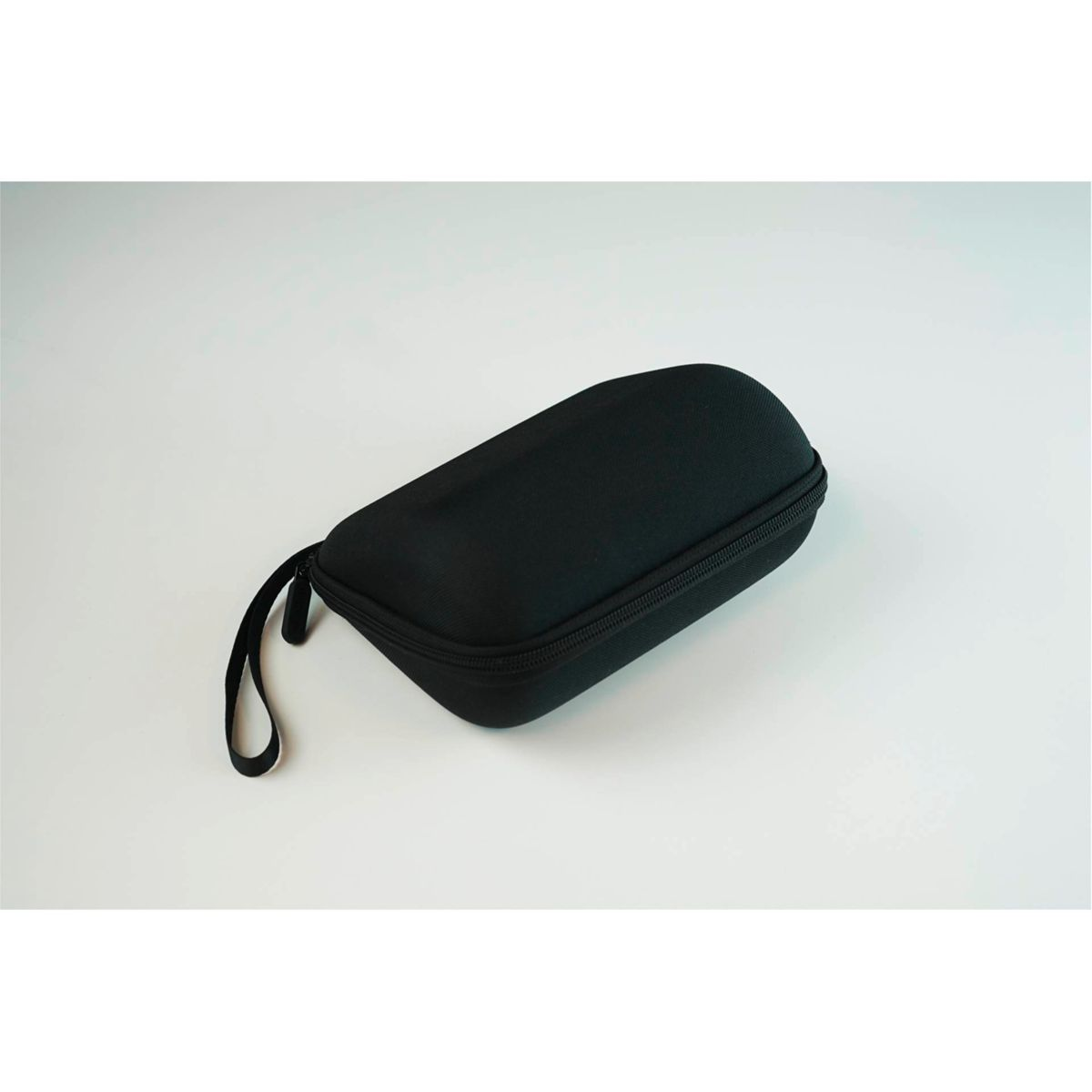 Schwarzes Etui mit Reißverschluss auf weißer Oberfläche, mit Griff.