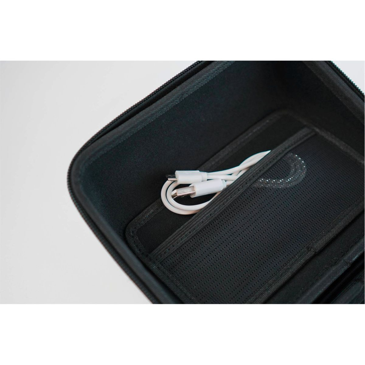 Geöffnete schwarze Hülle mit Reißverschluss, Tasche mit weißem USB-Kabel.