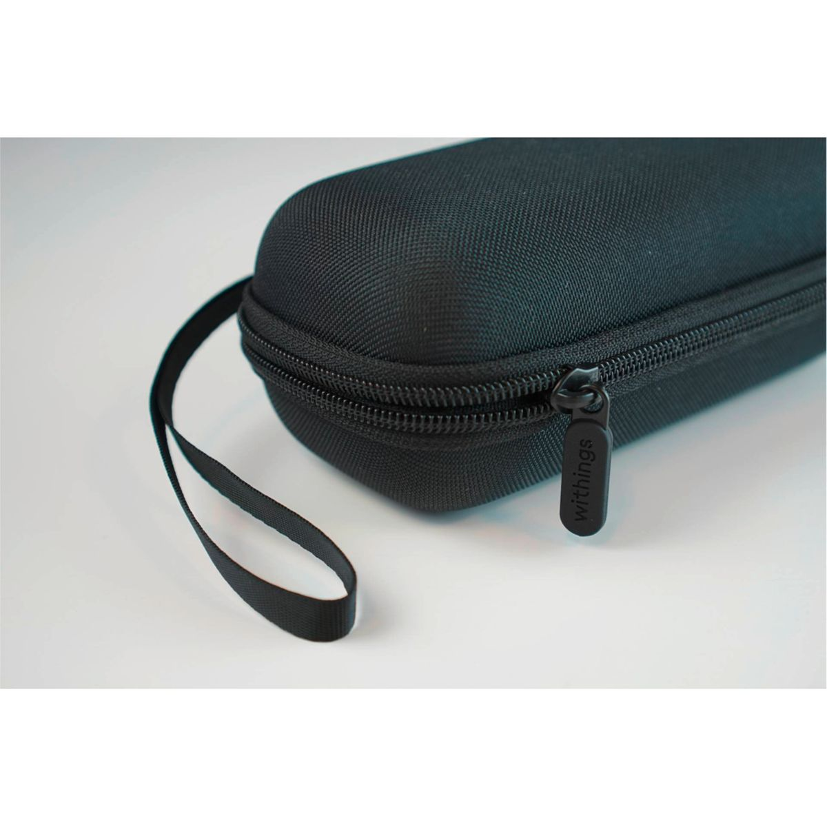 Schwarzes, ovalförmiges Etui mit Reißverschluss und kurzem Griff. Die Marke 'withings' steht auf dem Reißverschluss.