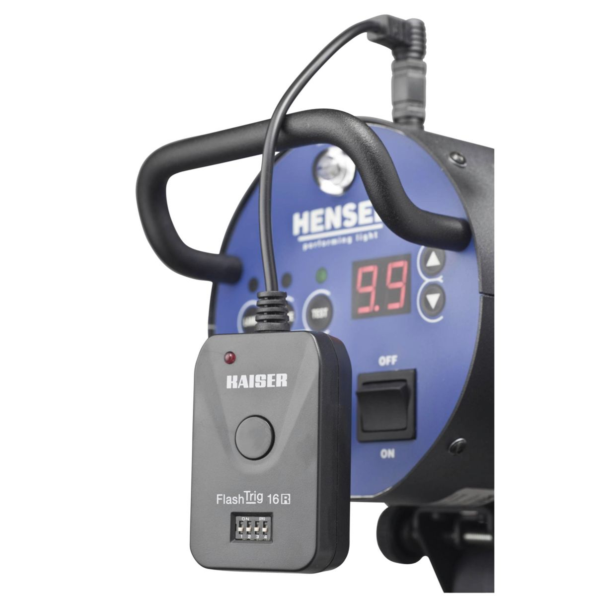 Schwarzes Kaiser FlashTrig 16R an einem grauen Licht befestigt. Blauer Hintergrund.
