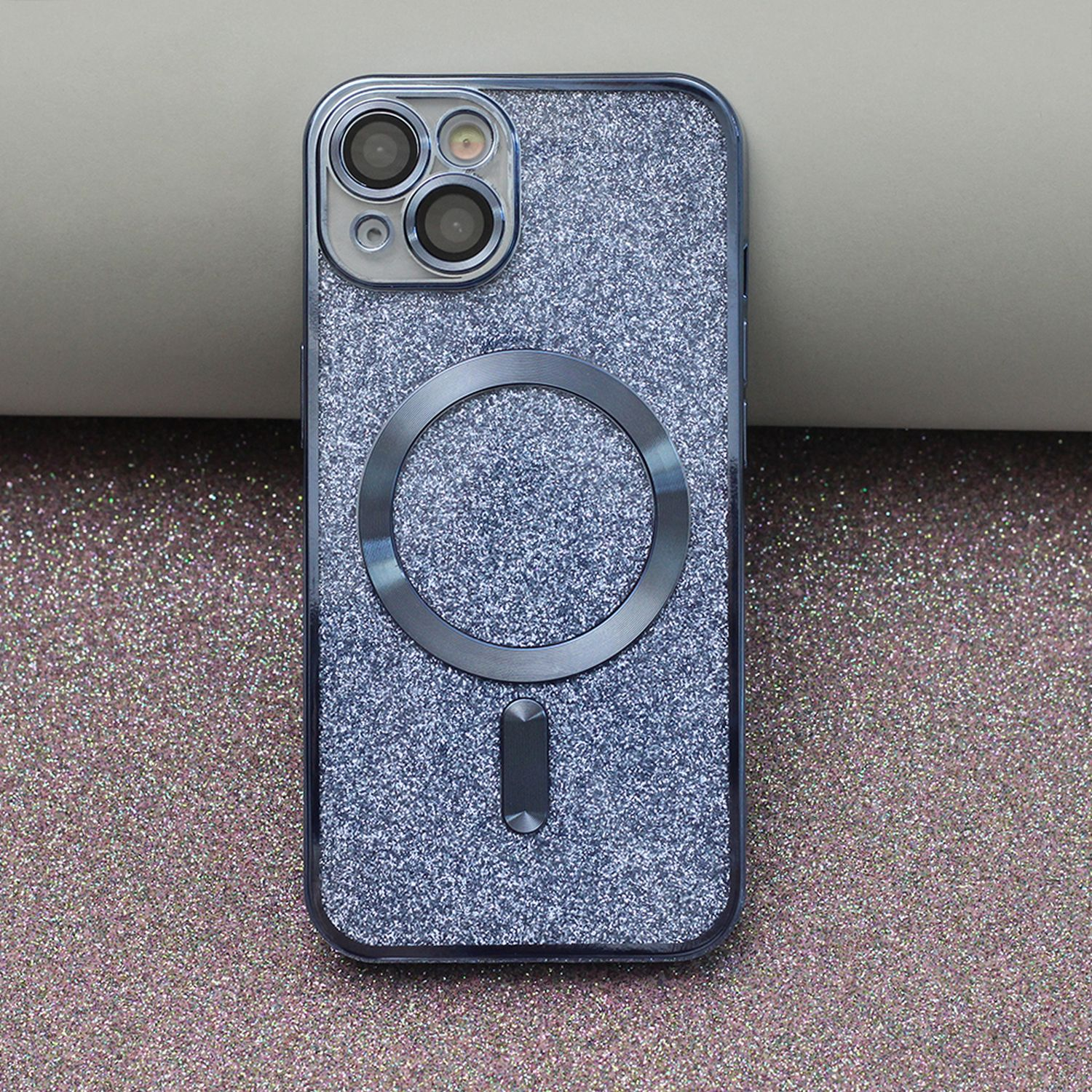 Eine glitzernde Handyhülle mit dunklem grauem Kameraausschnitt und Magnetring.