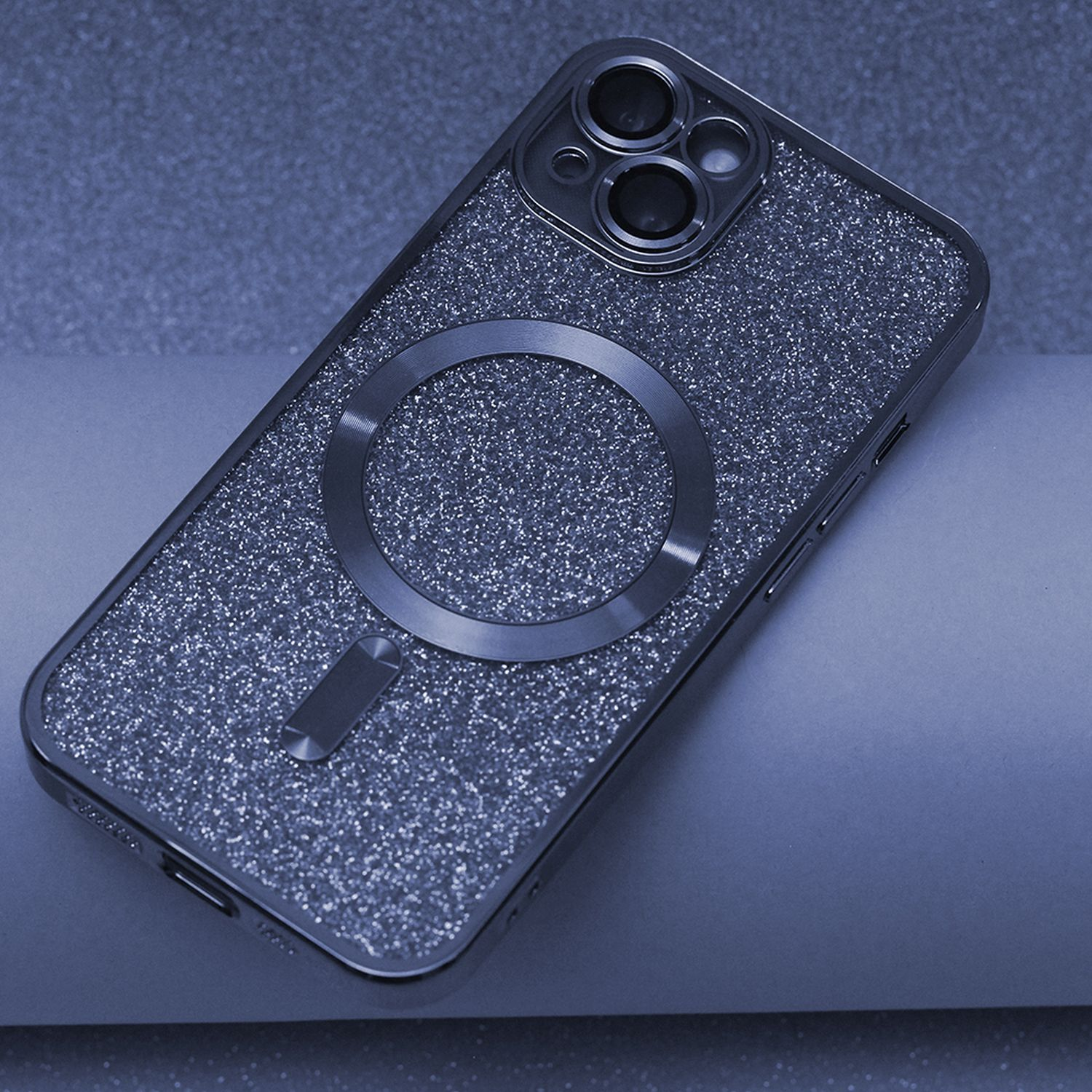 Custodia per telefono glitterata con un magnete circolare. Argento lucido, sfondo blu scuro.