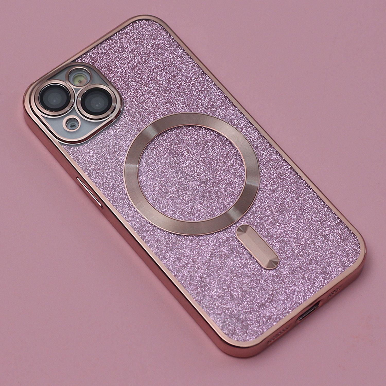 Rosa Glitzer-Handyhülle mit goldenem Ring für ein magnetisches Ladegerät. Rosa Hintergrund.
