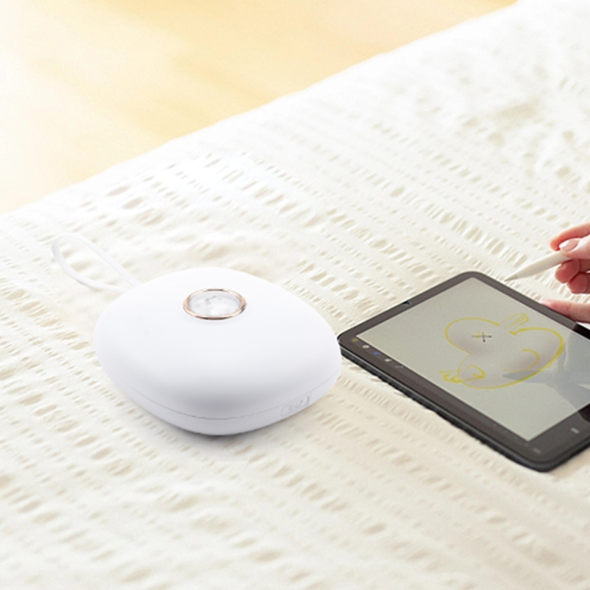 Białe, zaokrąglone urządzenie z tabletem do rysowania i osoba używająca rysika na ekranie.