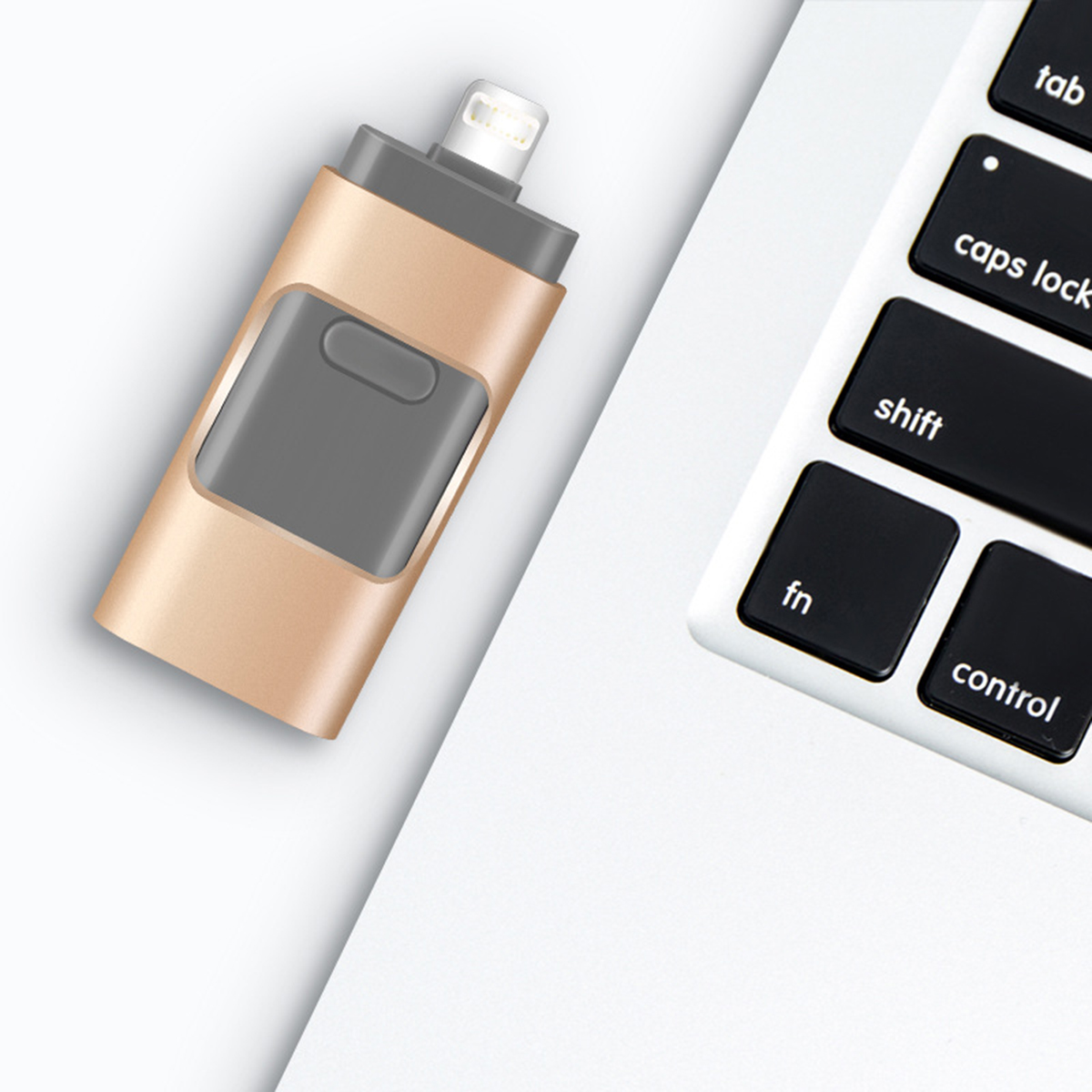 Ein gold-grauer USB-Stick, der in einen Laptop eingesteckt ist, von oben gesehen.