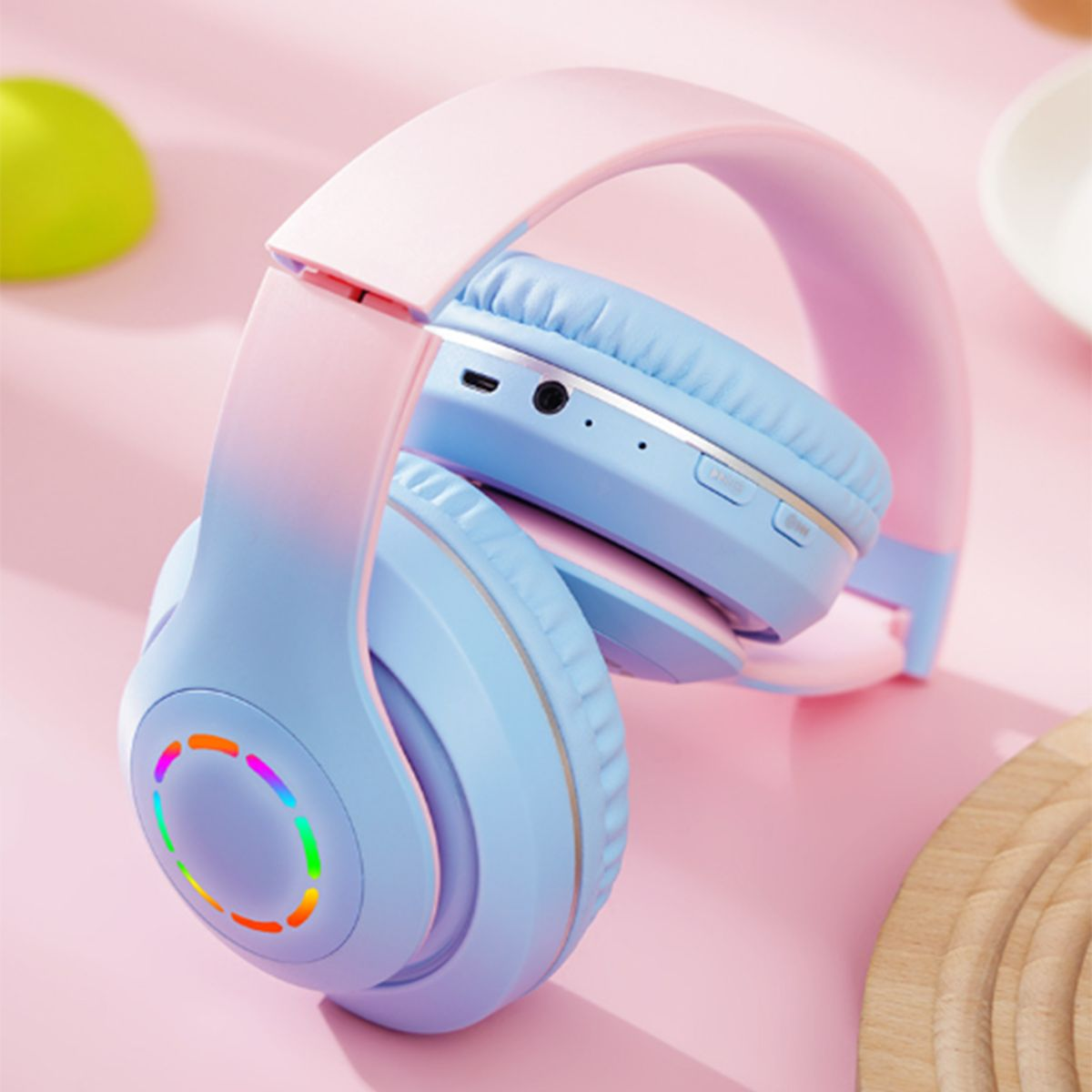 Blaue und rosa Kopfhörer mit farbwechselnden Ohrmuscheln. Auf rosa Hintergrund.