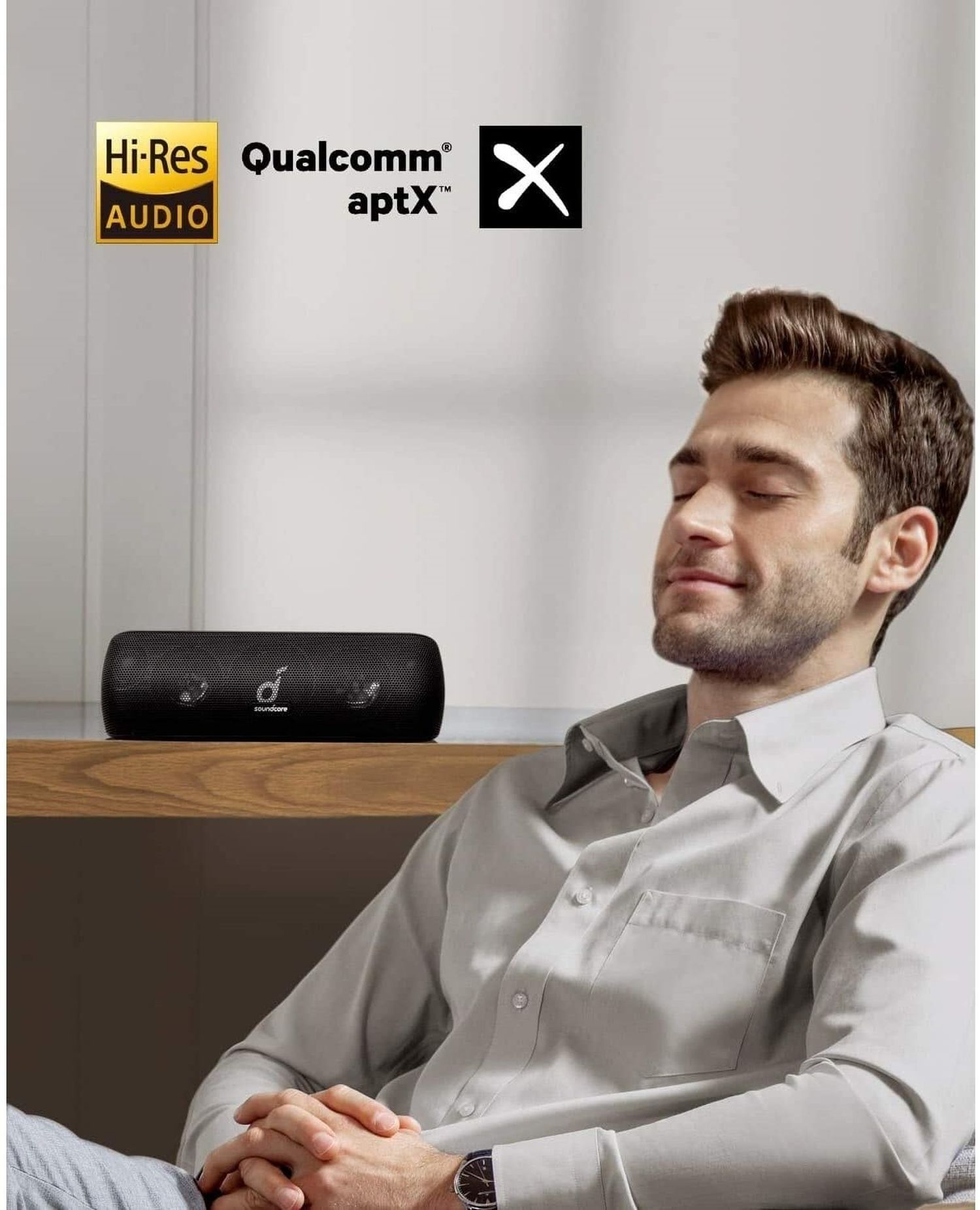 Kapalı gözlü, siyah bir soundbar dinleyen bir adam. Hi-Res ses ve diğer logolar.