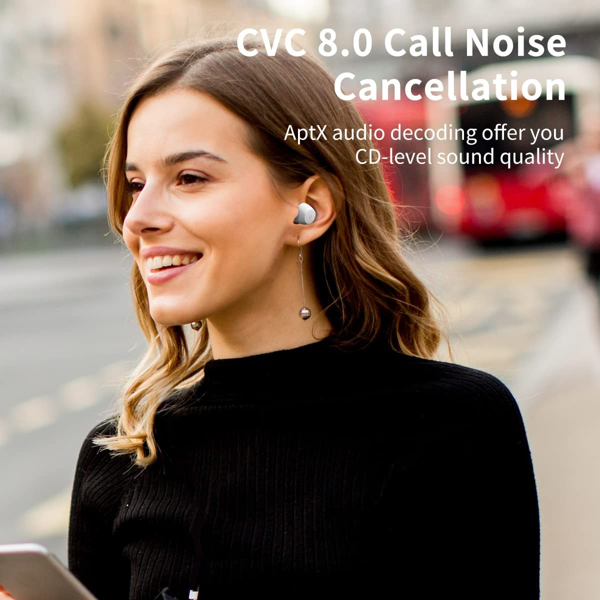 Uśmiechnięta kobieta w czarnej koszuli i bezprzewodowych słuchawkach.