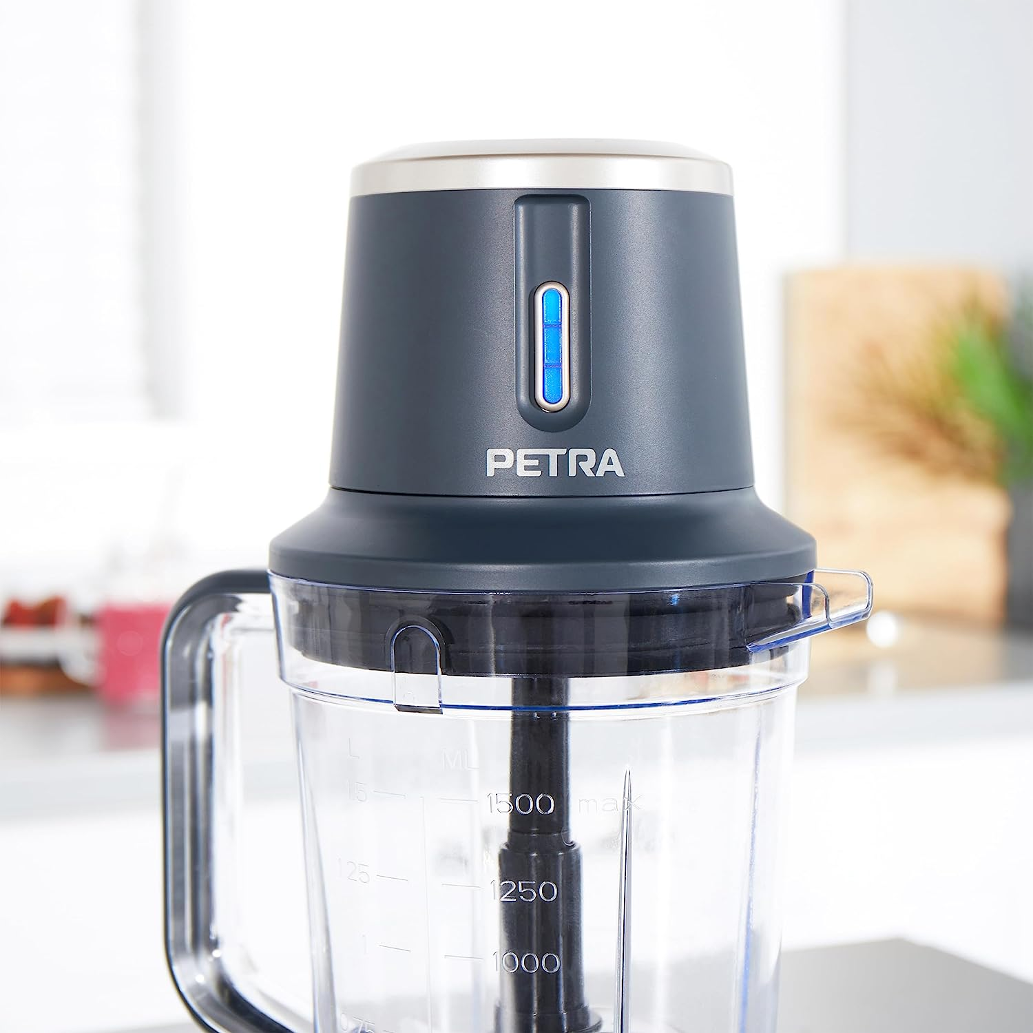 Ein dunkelgrauer Petra-Foodprozessor. Der Behälter hat Messmarkierungen und den Markennamen.