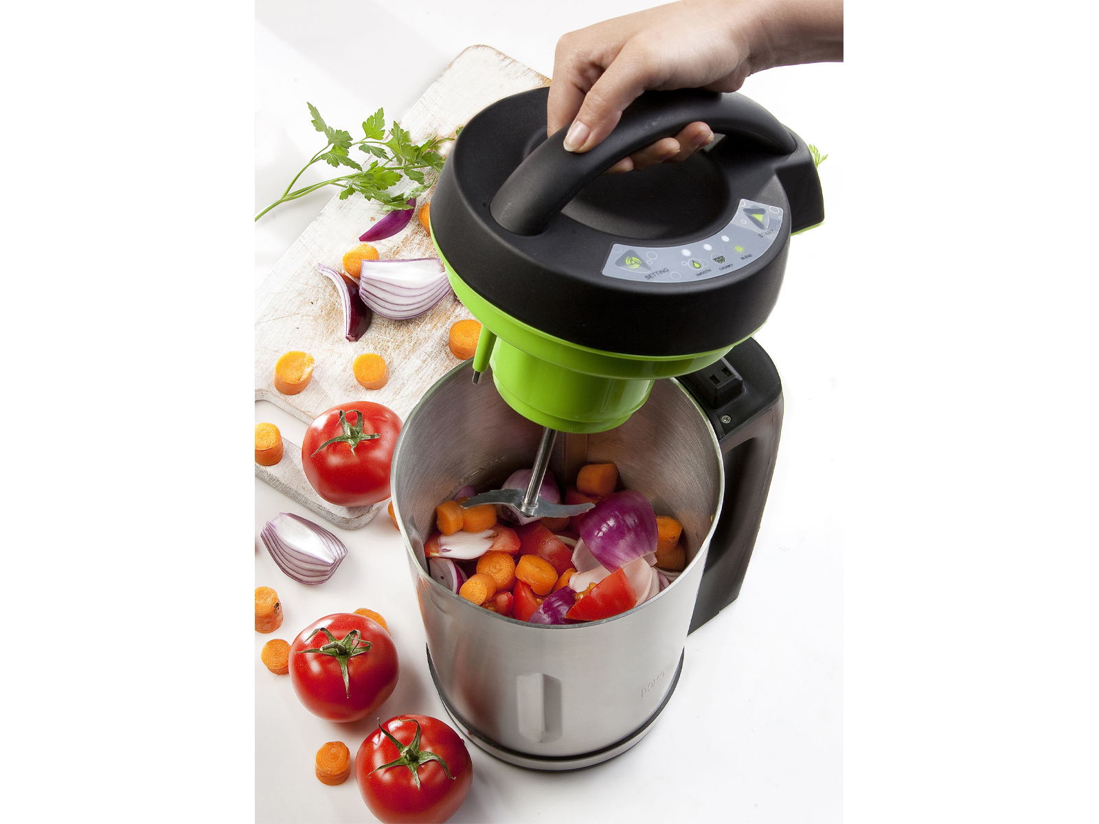 Un frullatore con verdure all'interno, con pomodori e cipolle tagliati.