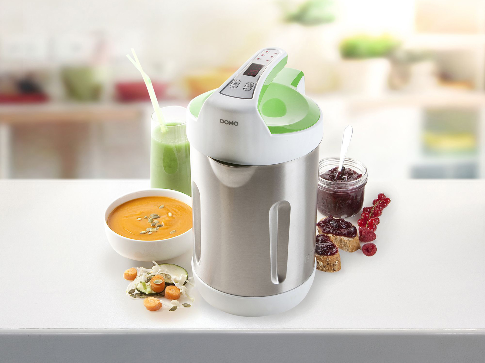Un robot da cucina con zuppa, verdure, marmellata e pane su una superficie bianca.
