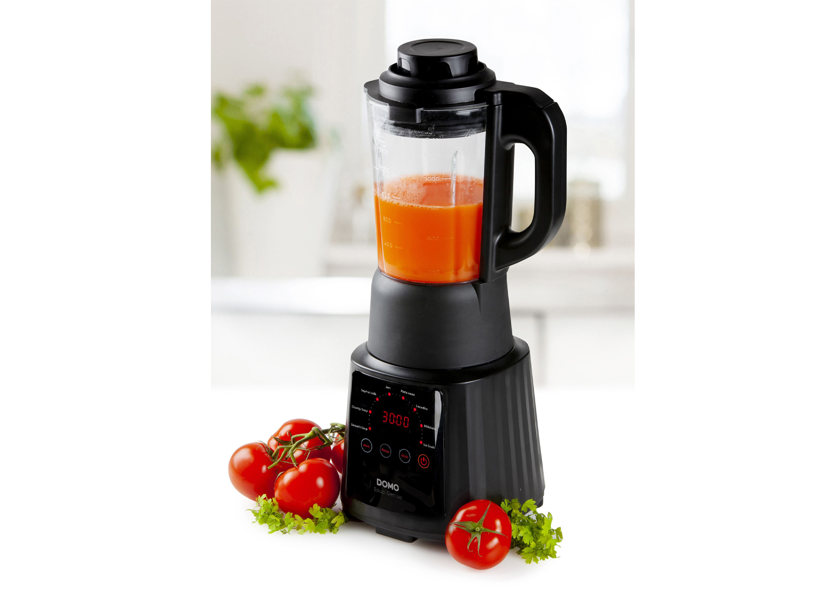 Ein schwarzer Mixer mit Tomaten und Petersilie auf weißer Oberfläche. Küchenhintergrund.