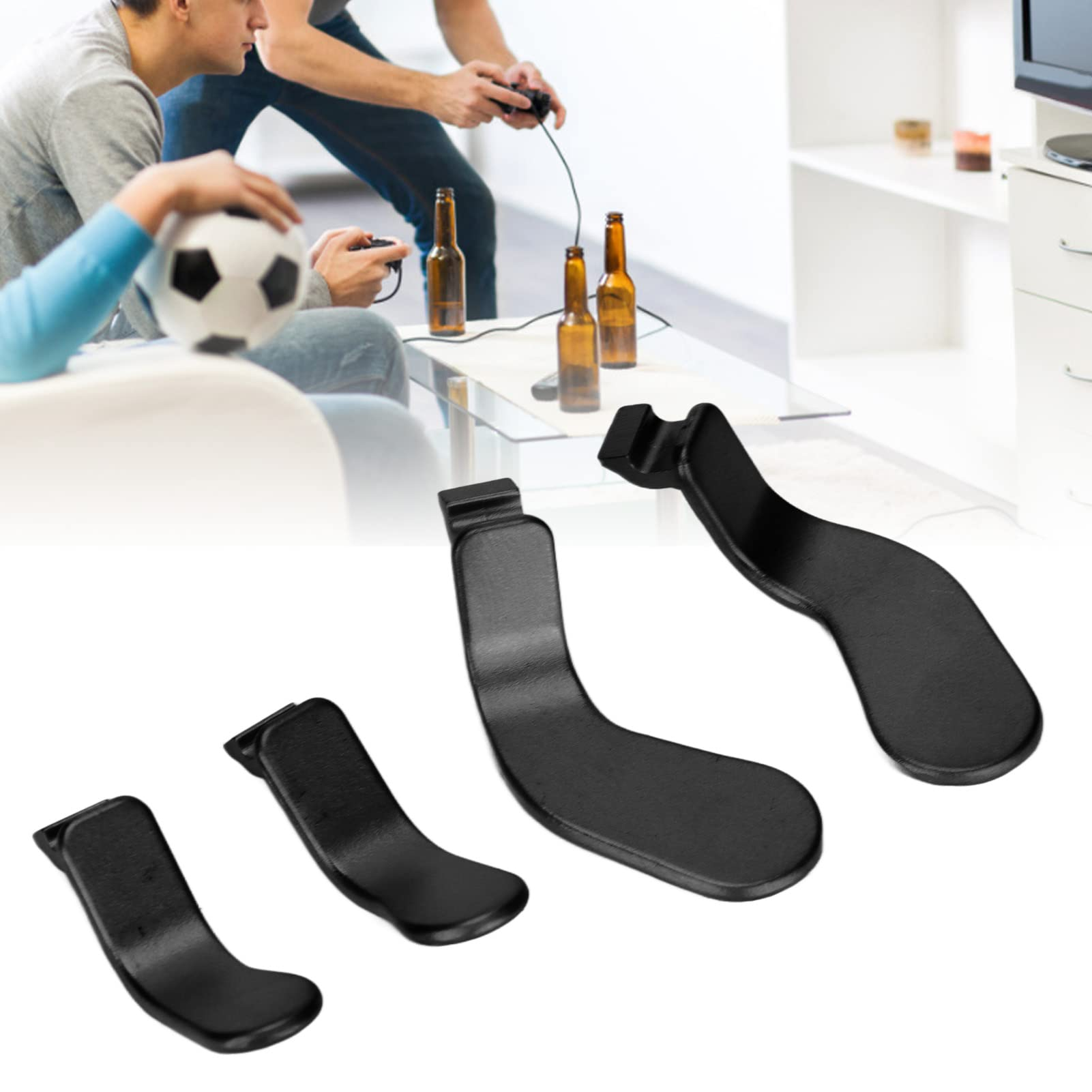 Eine Gruppe schwarzer Gamecontroller-Aufsätze. Zwei Personen spielen im Hintergrund Videospiele.