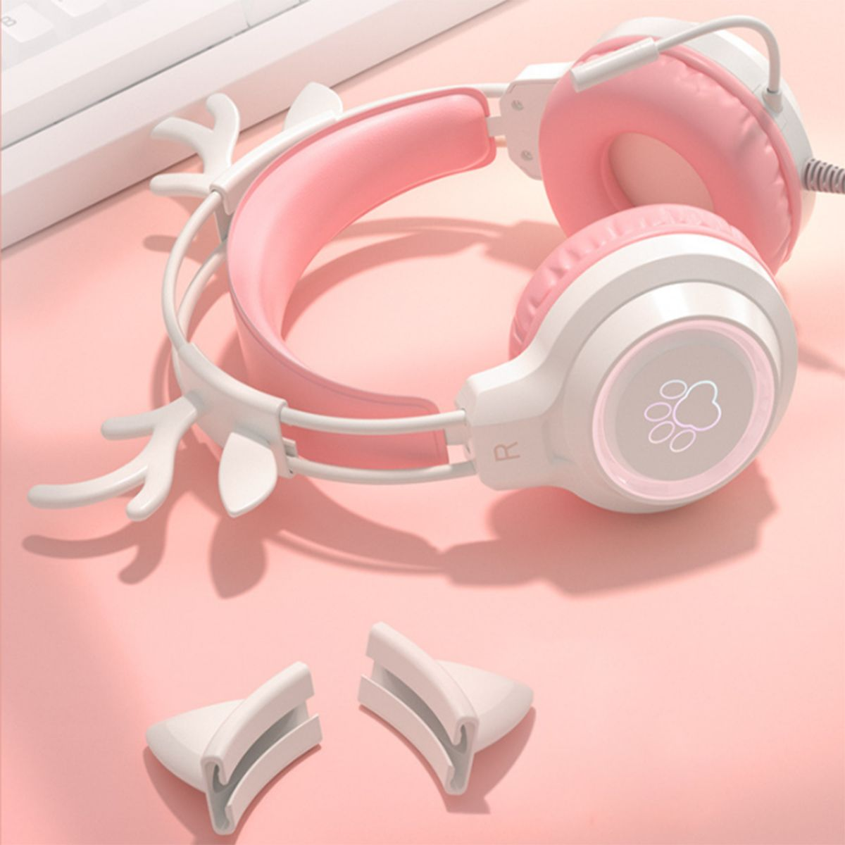Rosa-weißes Gaming-Headset mit Hirschgeweih und zwei Ohrenabdeckungen. Rosa Hintergrund.