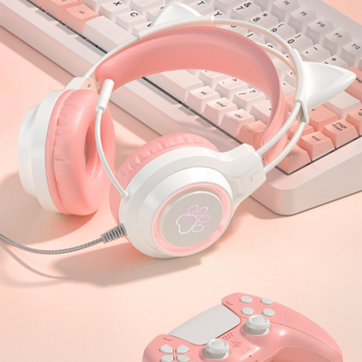 Rosa-weiße Katzenohrkopfhörer auf Tastatur und rosa Controller.
