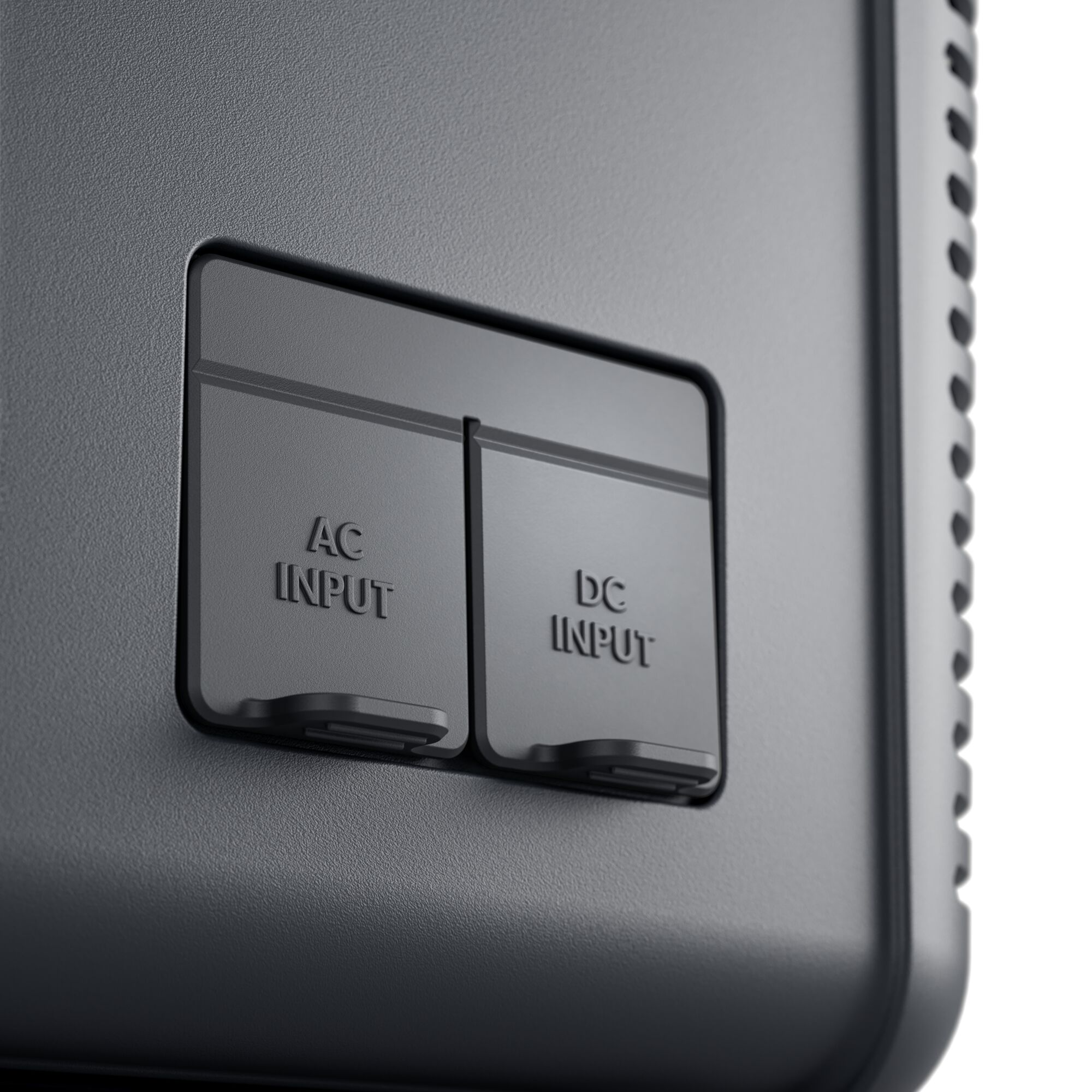 Zbliżenie ciemnych portów wejściowych AC i DC. Widoczne etykiety tekstowe 'AC INPUT' i 'DC INPUT'.