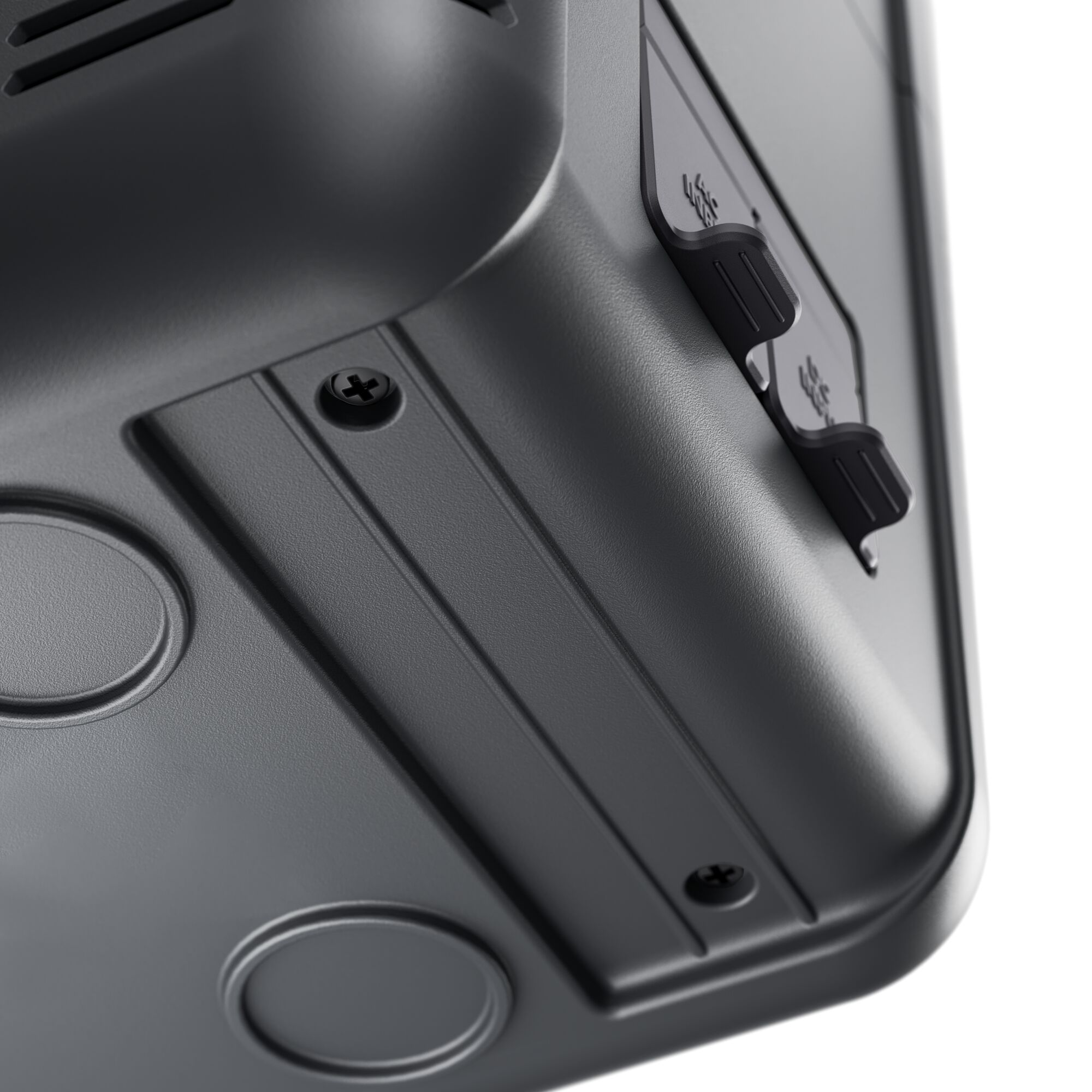 Zbliżenie ciemnoszarego elementu elektrycznego ze śrubami i panelem z przyciskami. Białe tło.