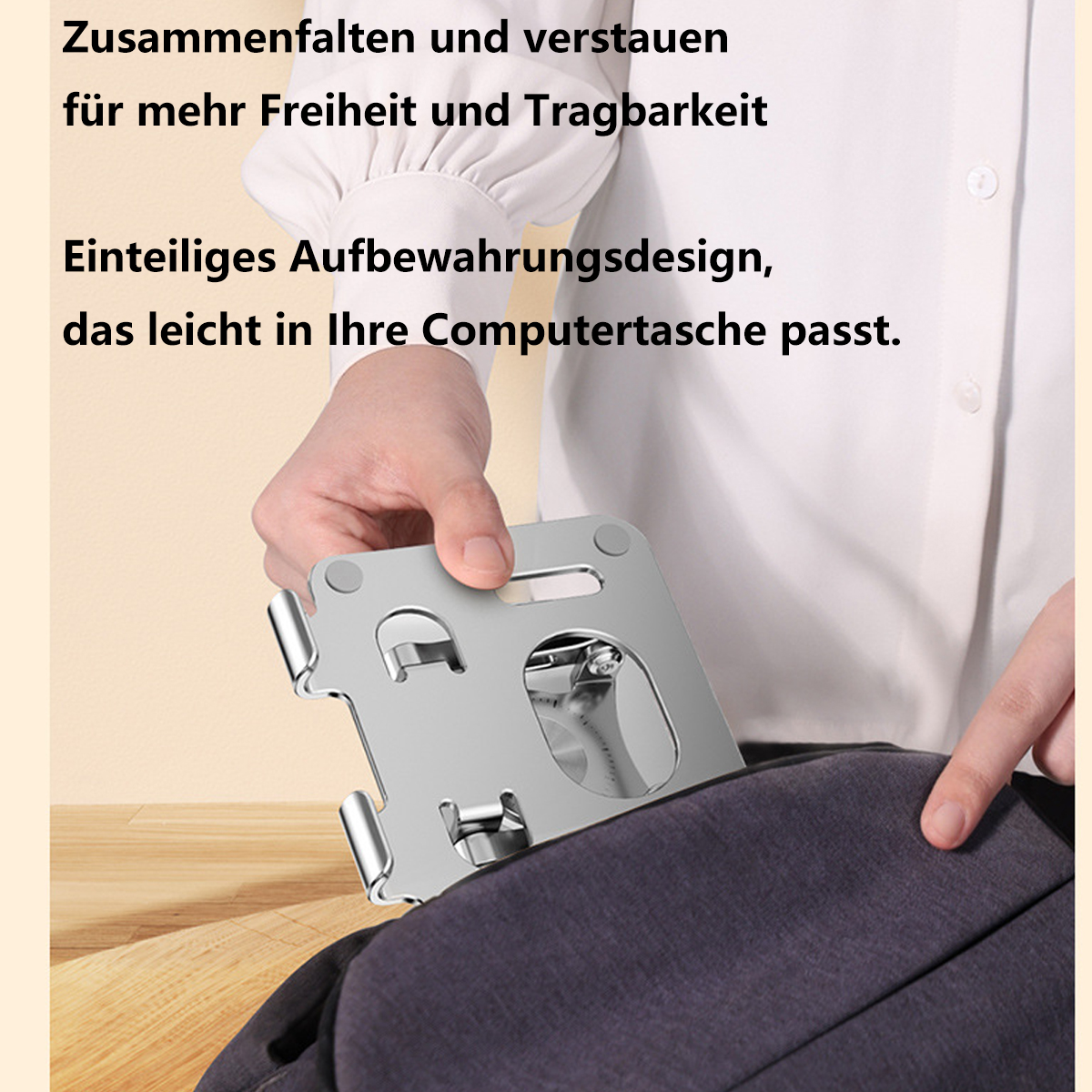 Die Hand einer Person legt einen silbernen Laptopständer in einen schwarzen Rucksack. Text auf Deutsch ist sichtbar.