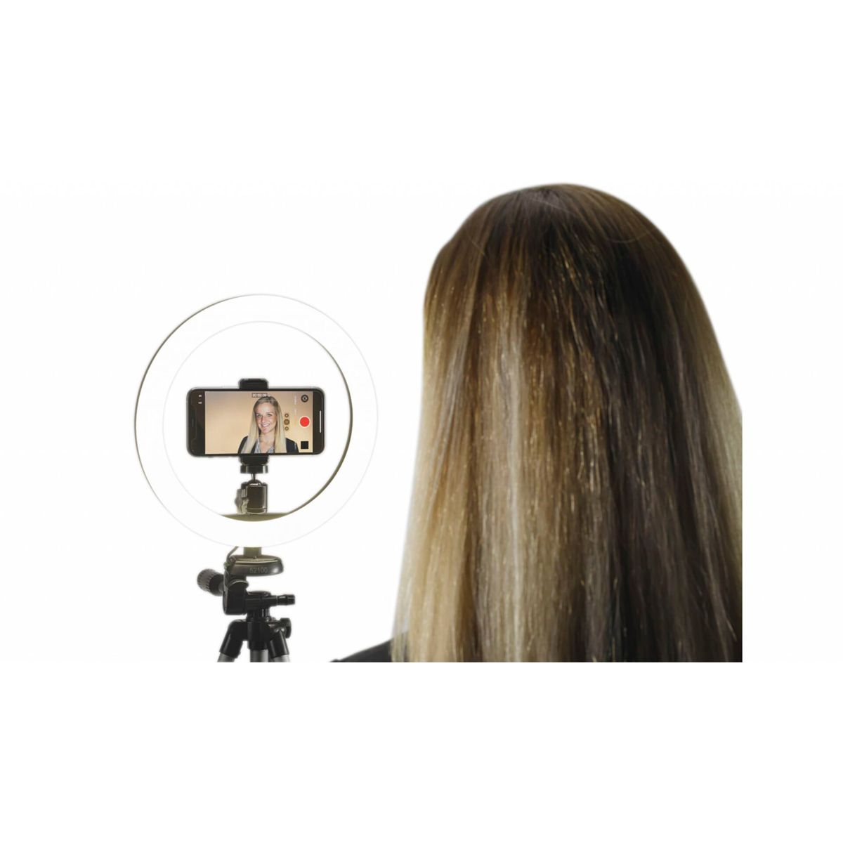 Frau mit blonden Haaren filmt sich selbst mit einem Telefon auf einem Stativ mit einem Ringlicht.