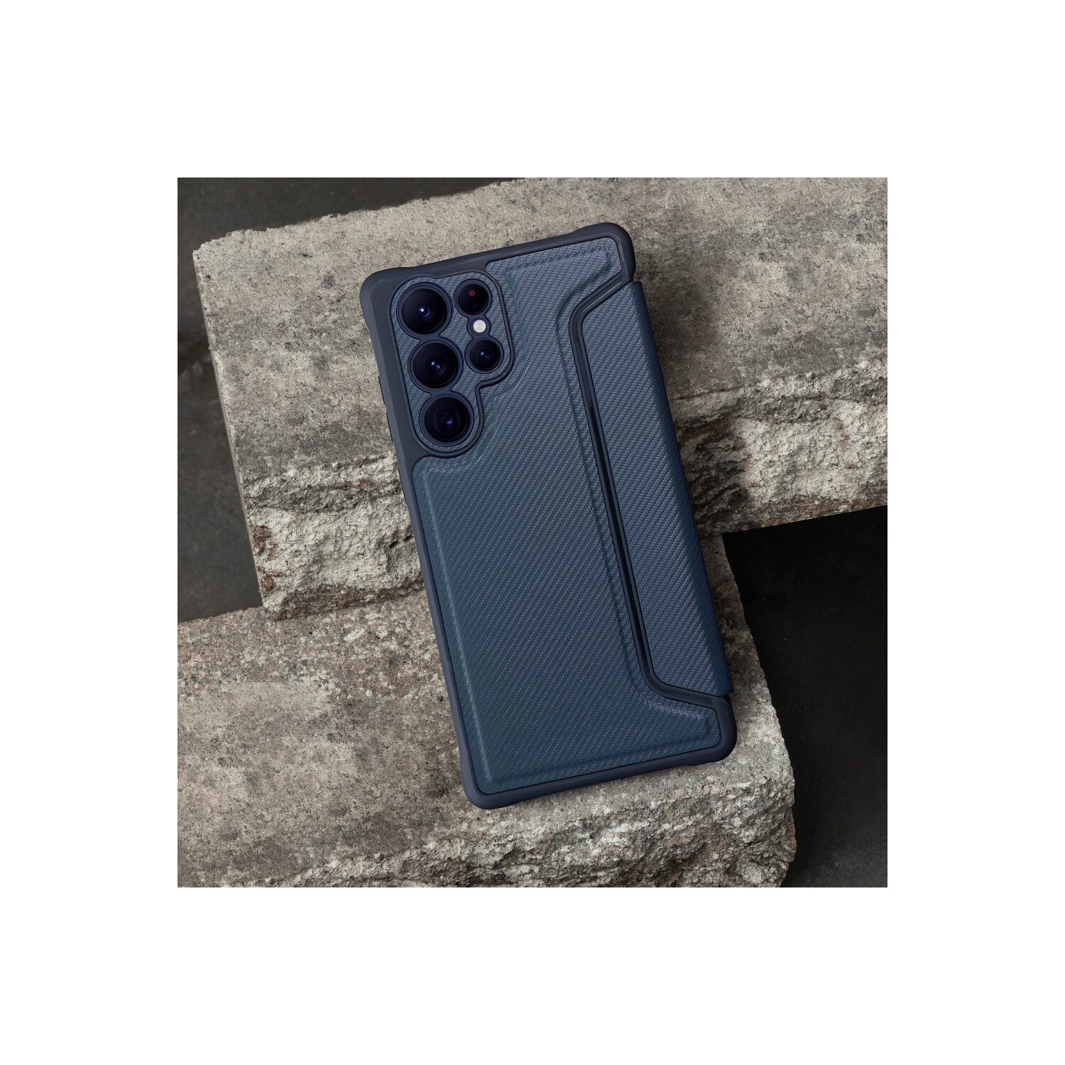 Una custodia per telefono blu scuro su una superficie di pietra strutturata. La custodia ha un ritaglio per la fotocamera e un lembo a portafoglio.