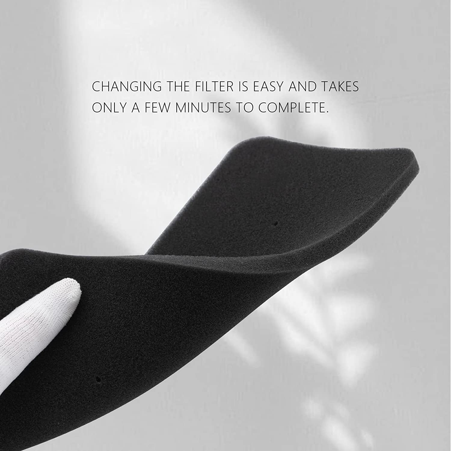 Ręka trzymająca czarny filtr piankowy, tekst o wymianie.