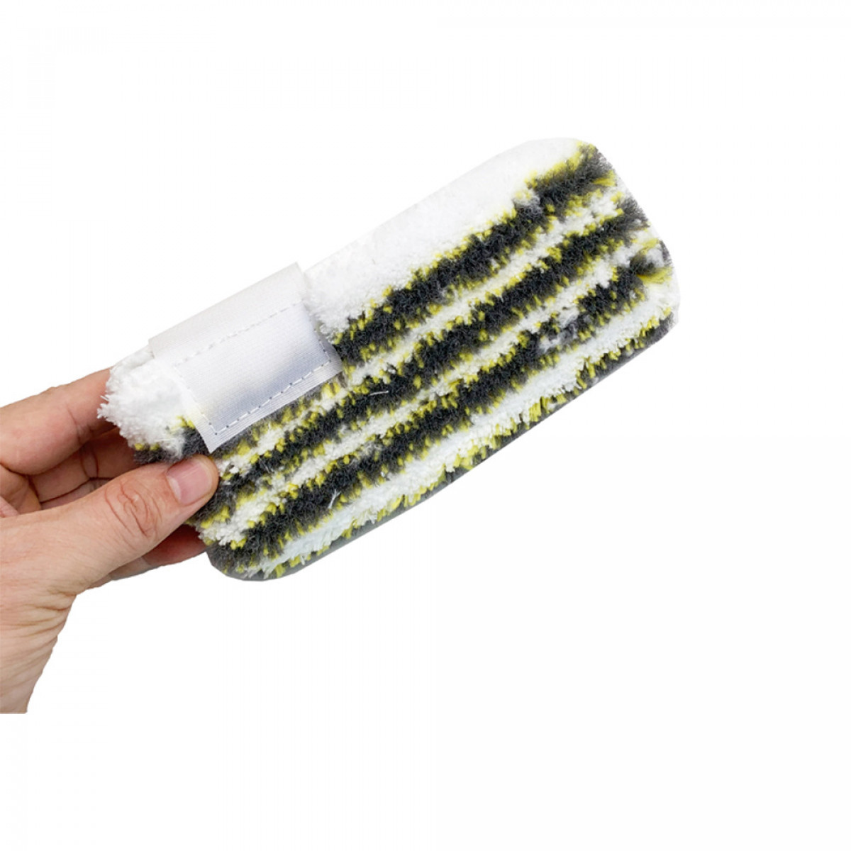 Dłoń trzymająca biało-czarną nakładkę do mopa z żółtymi paskami. Widoczny pasek na rzep.