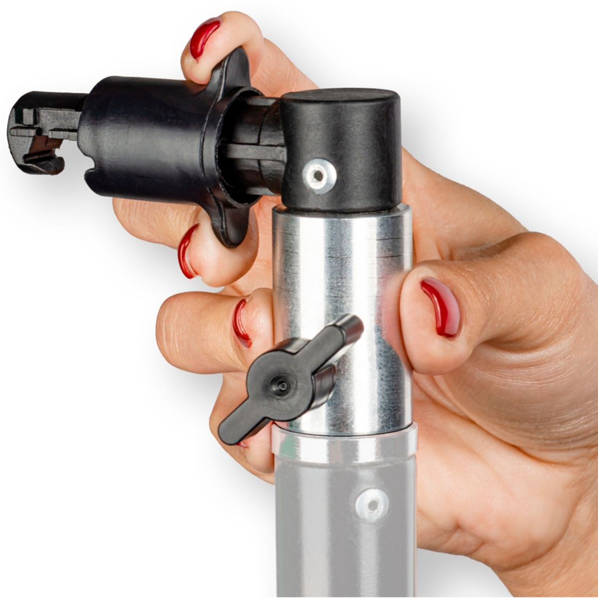 Eine Hand, die einen Anschluss an einem Lichtstativ einstellt. Schwarzer Stecker, roter Nagellack.