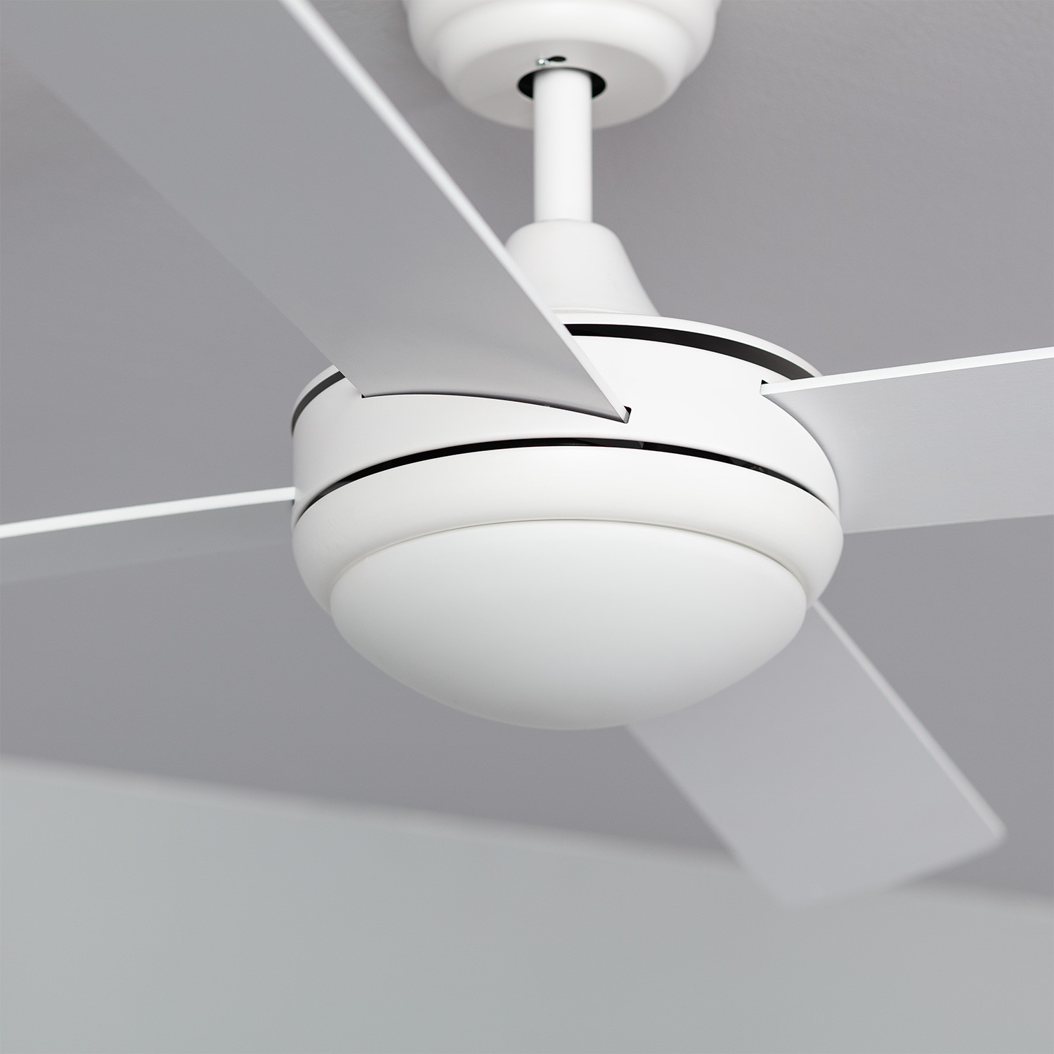 Ventilatore da soffitto bianco con quattro pale e luce, visto dal basso.