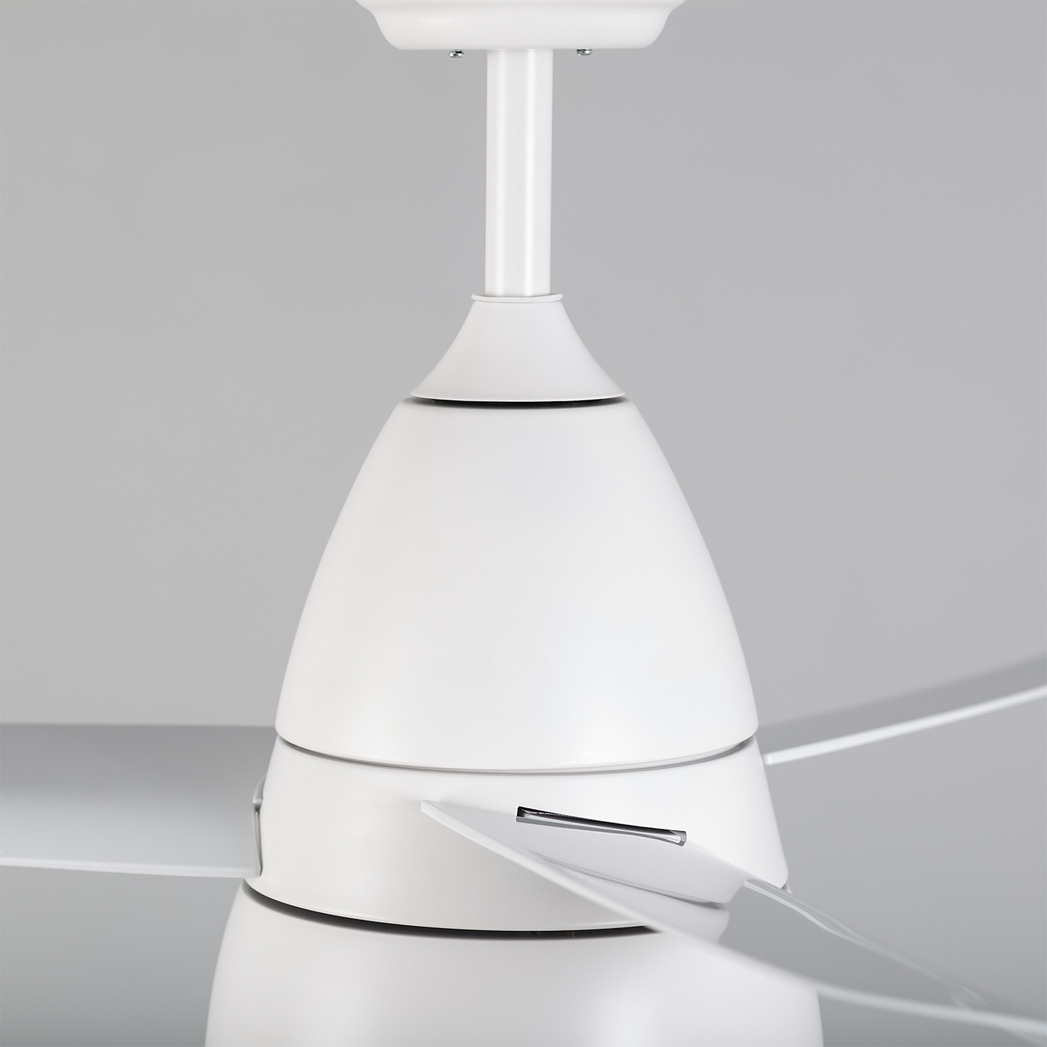 Un ventilatore da soffitto bianco, vista ravvicinata dell'alloggiamento del motore e delle pale.