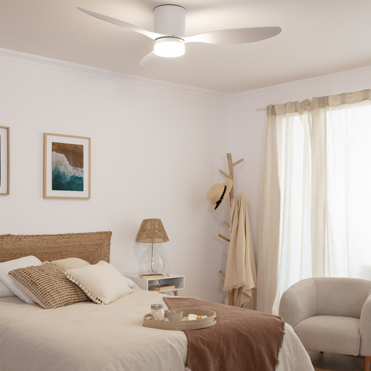 Camera da letto con ventilatore a soffitto bianco, letto, decorazioni e tenda.