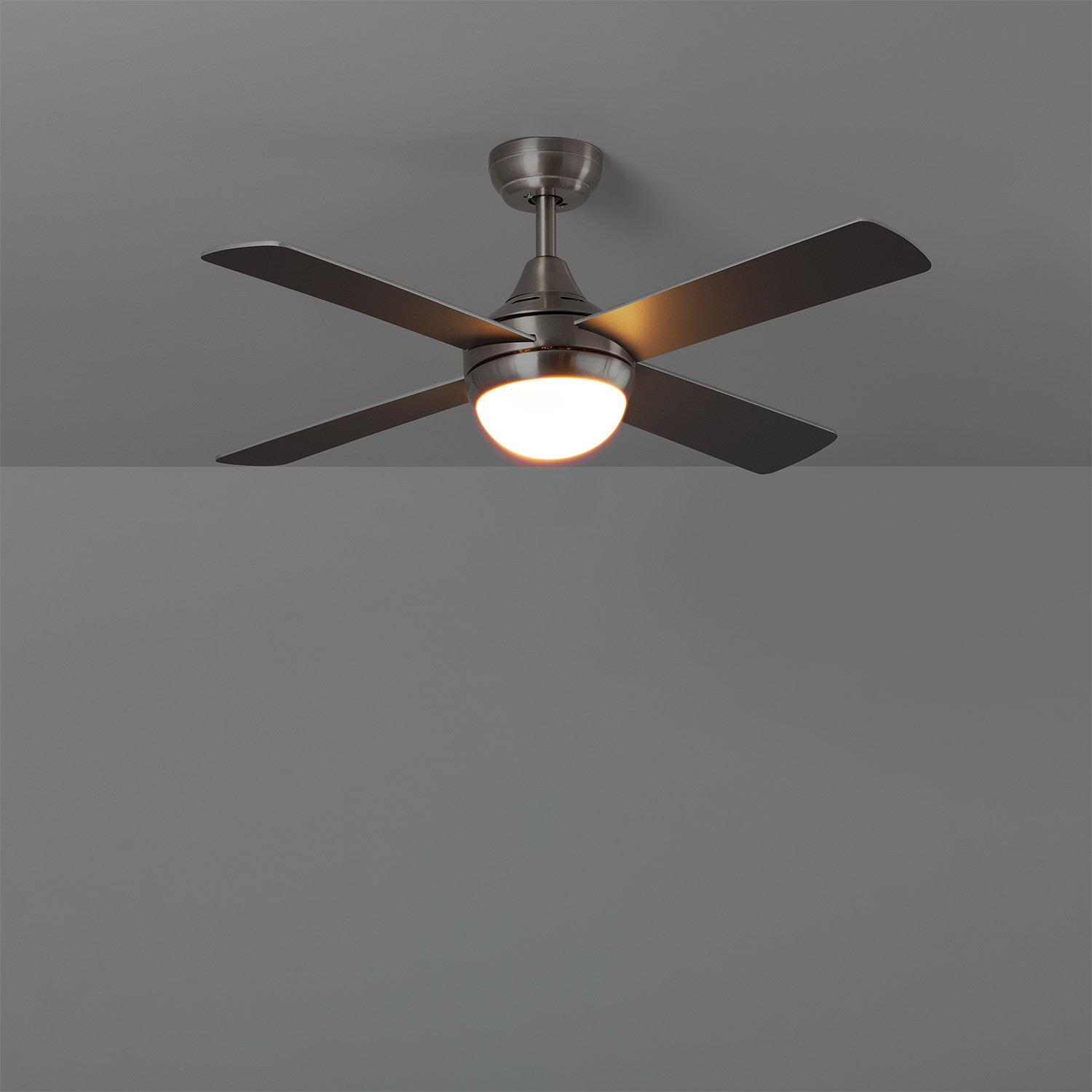 Un ventilatore da soffitto con quattro pale, luce al centro e uno sfondo grigio.