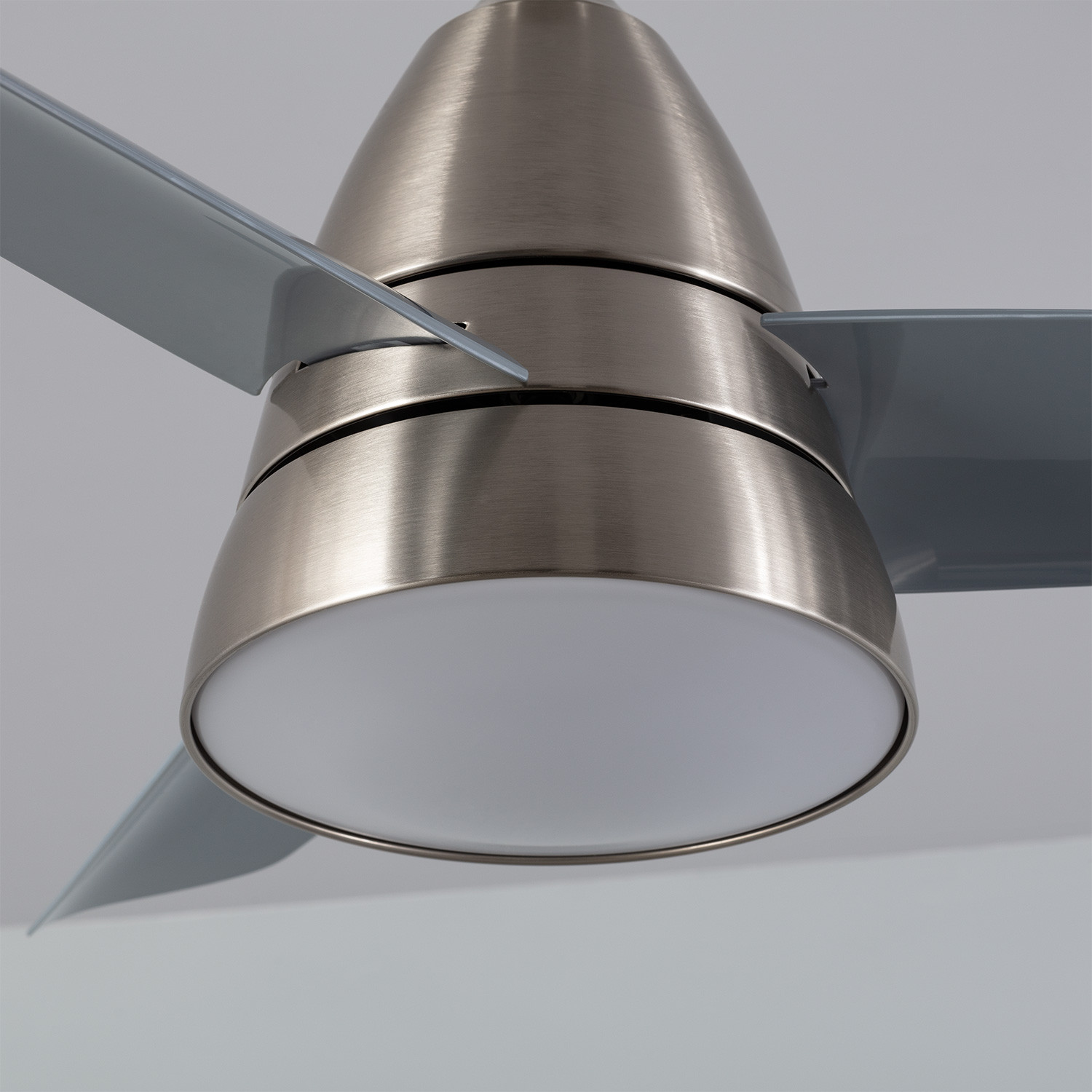 Primo piano di un ventilatore a soffitto, mostrando le pale e la luce.