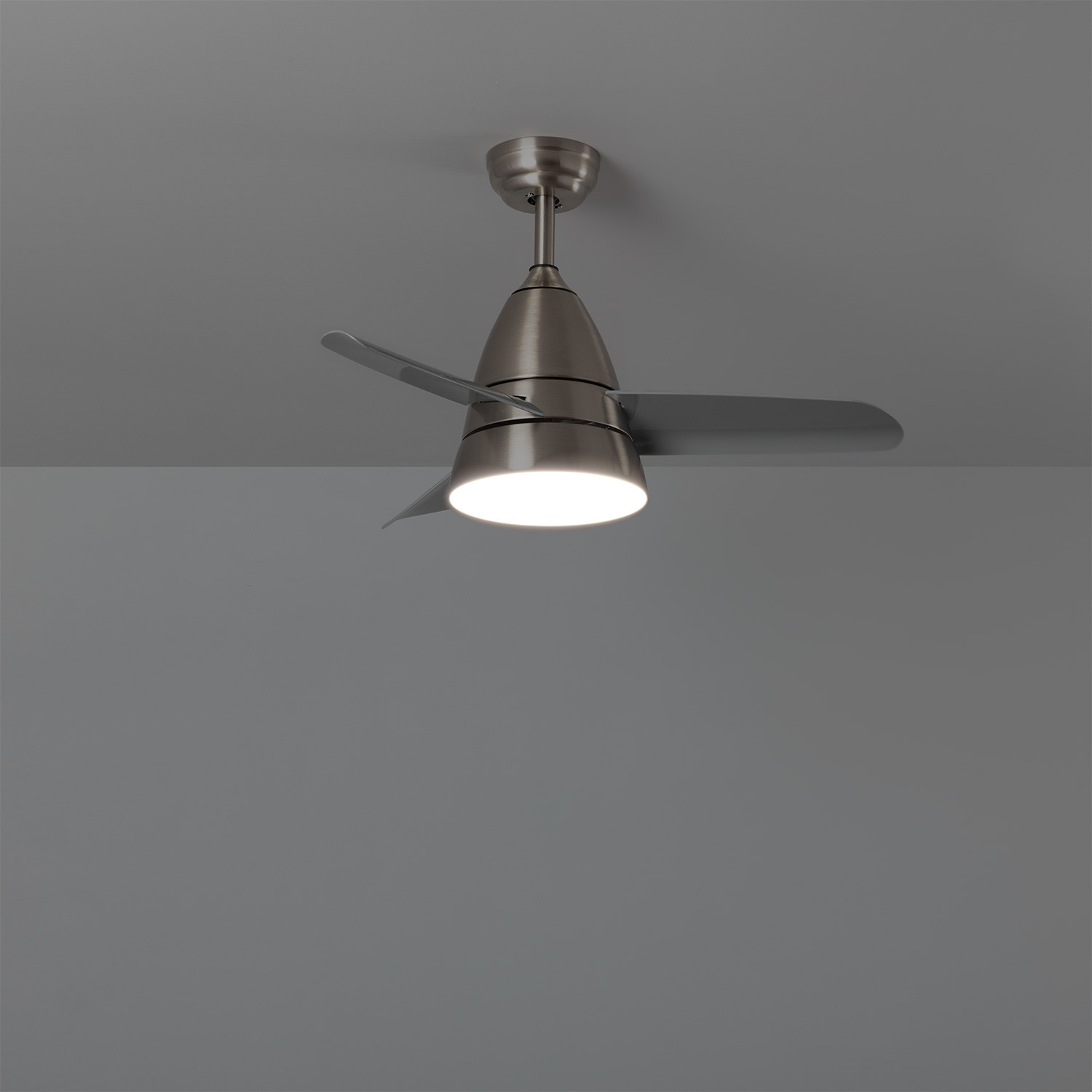 Ventilatore da soffitto con pale argentate e un apparecchio di illuminazione bianco. È montato su un soffitto grigio.