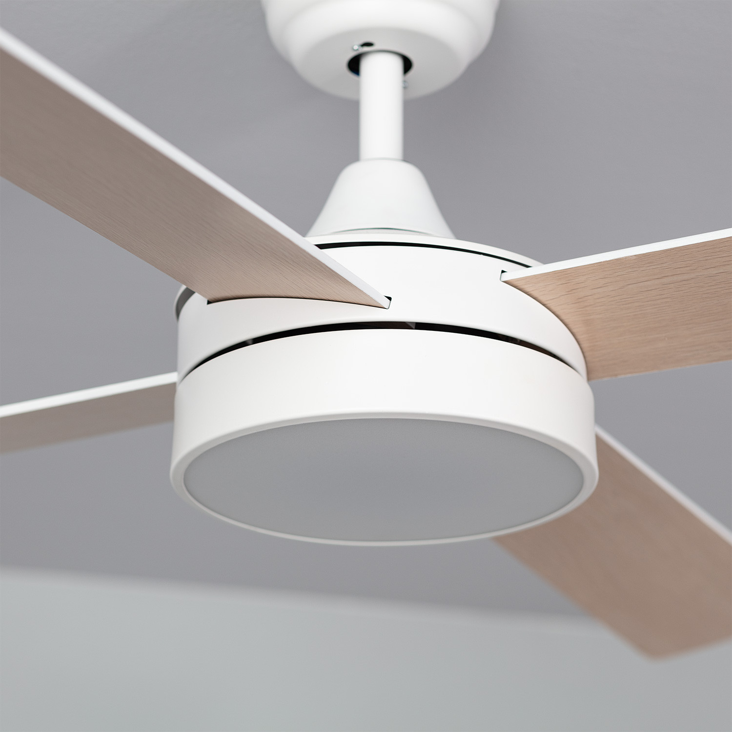 Primo piano di un ventilatore da soffitto bianco con pale in legno e una luce.