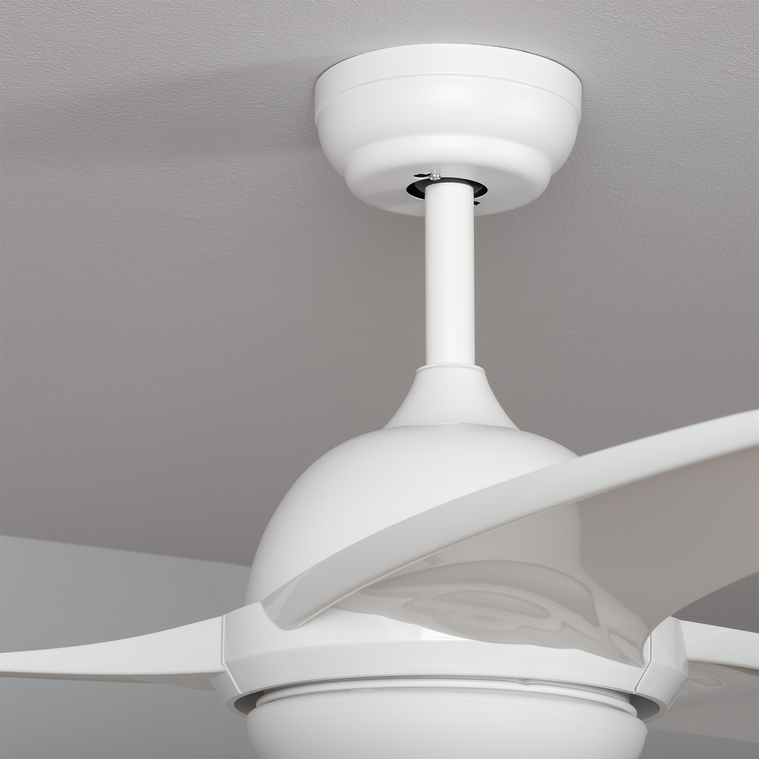 Ventilatore da soffitto bianco con tre pale curve contro un soffitto grigio.