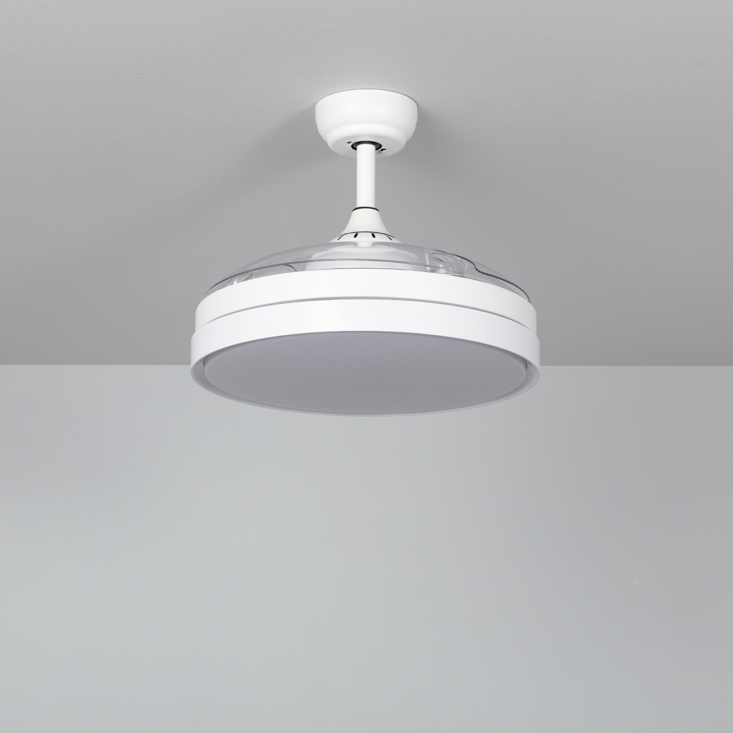 Ventilatore da soffitto bianco con pale trasparenti, su un soffitto grigio.