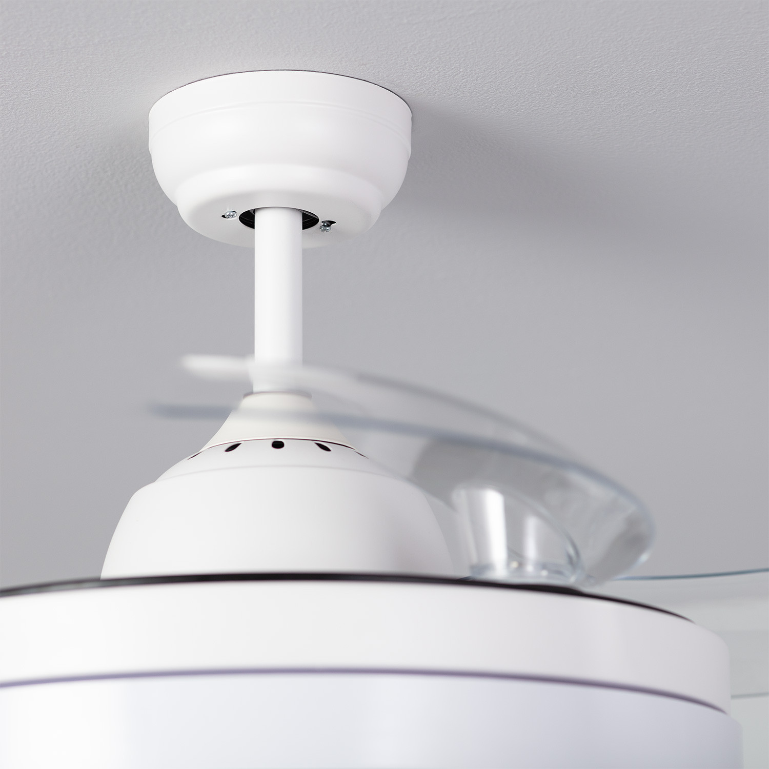 Primo piano del ventilatore a soffitto bianco con pale sfocate.