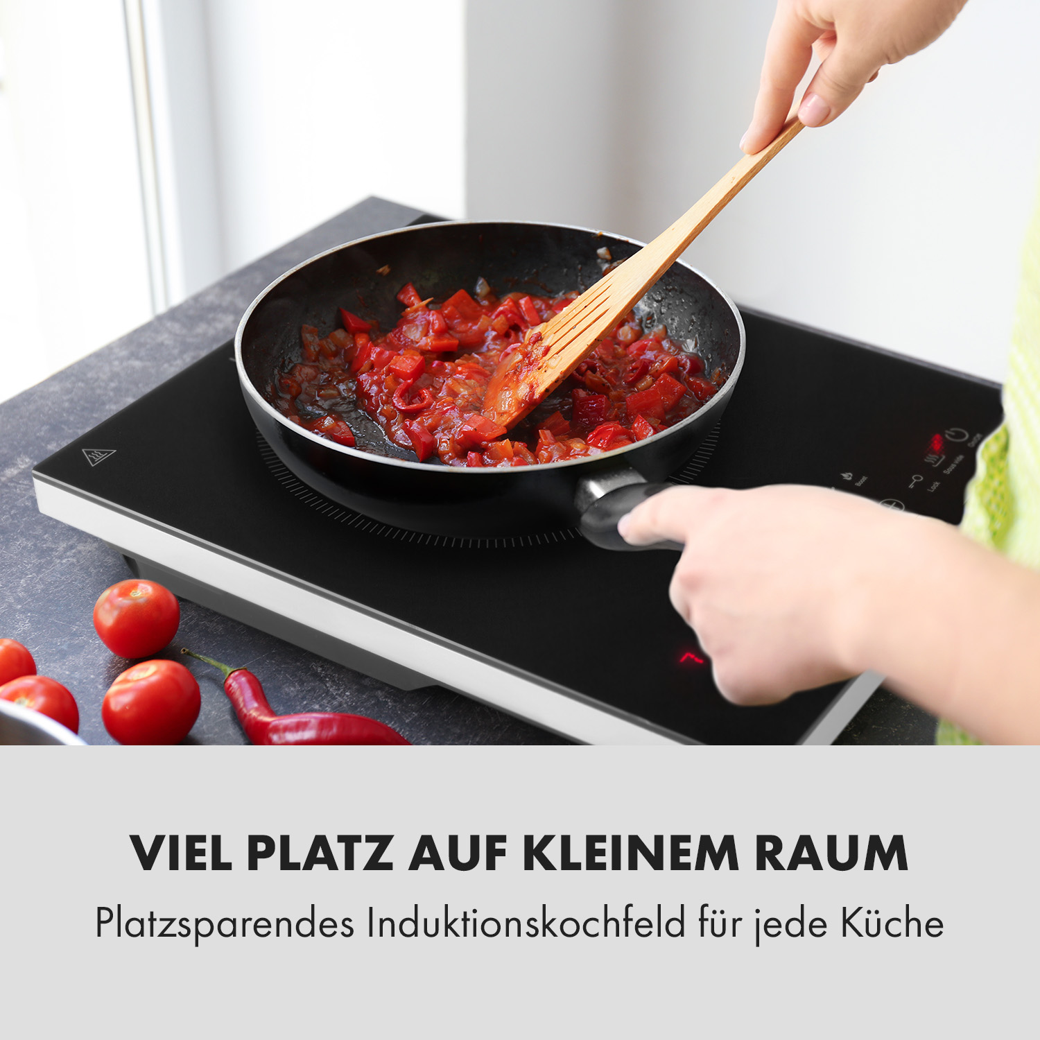 Eine Person rührt mit einem Holzlöffel Essen in einer Pfanne auf einem schwarzen Induktionskochfeld um.
