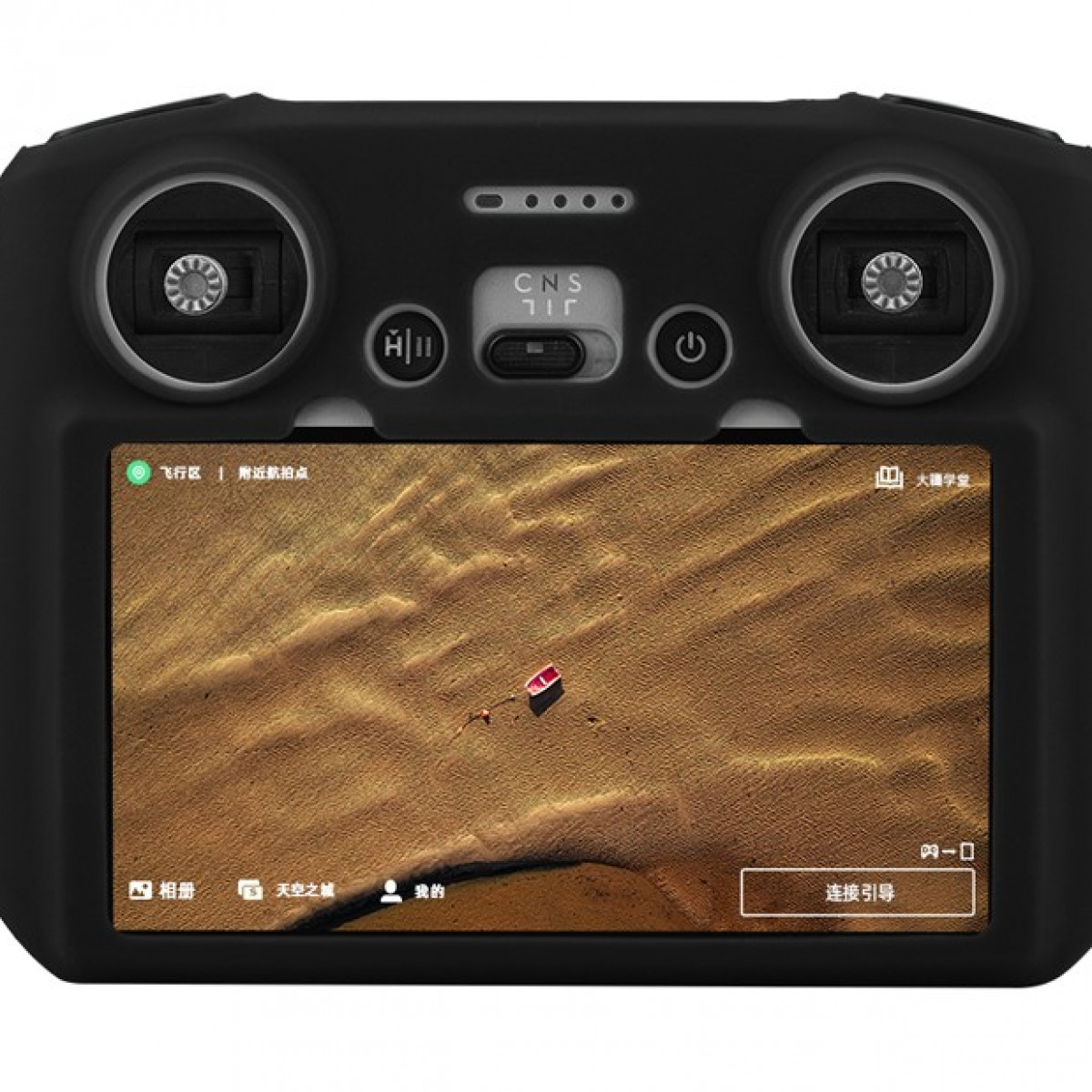 Drohnen-Controller in schwarzem Gehäuse mit Wüsten-Szene auf dem Bildschirm.