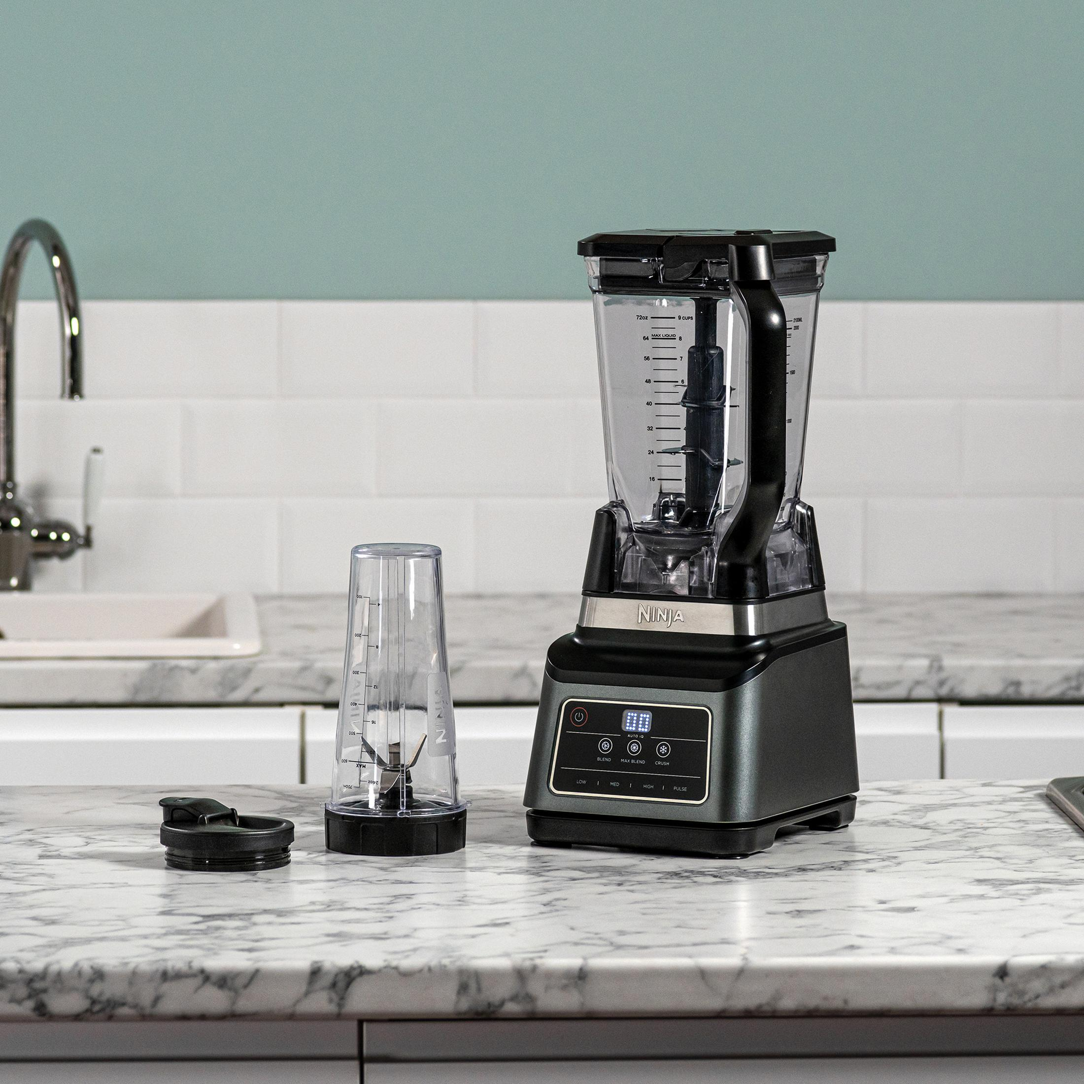 Blender z pojemnikiem i mniejszym mocowaniem ostrza. Znajduje się na marmurowej powierzchni.