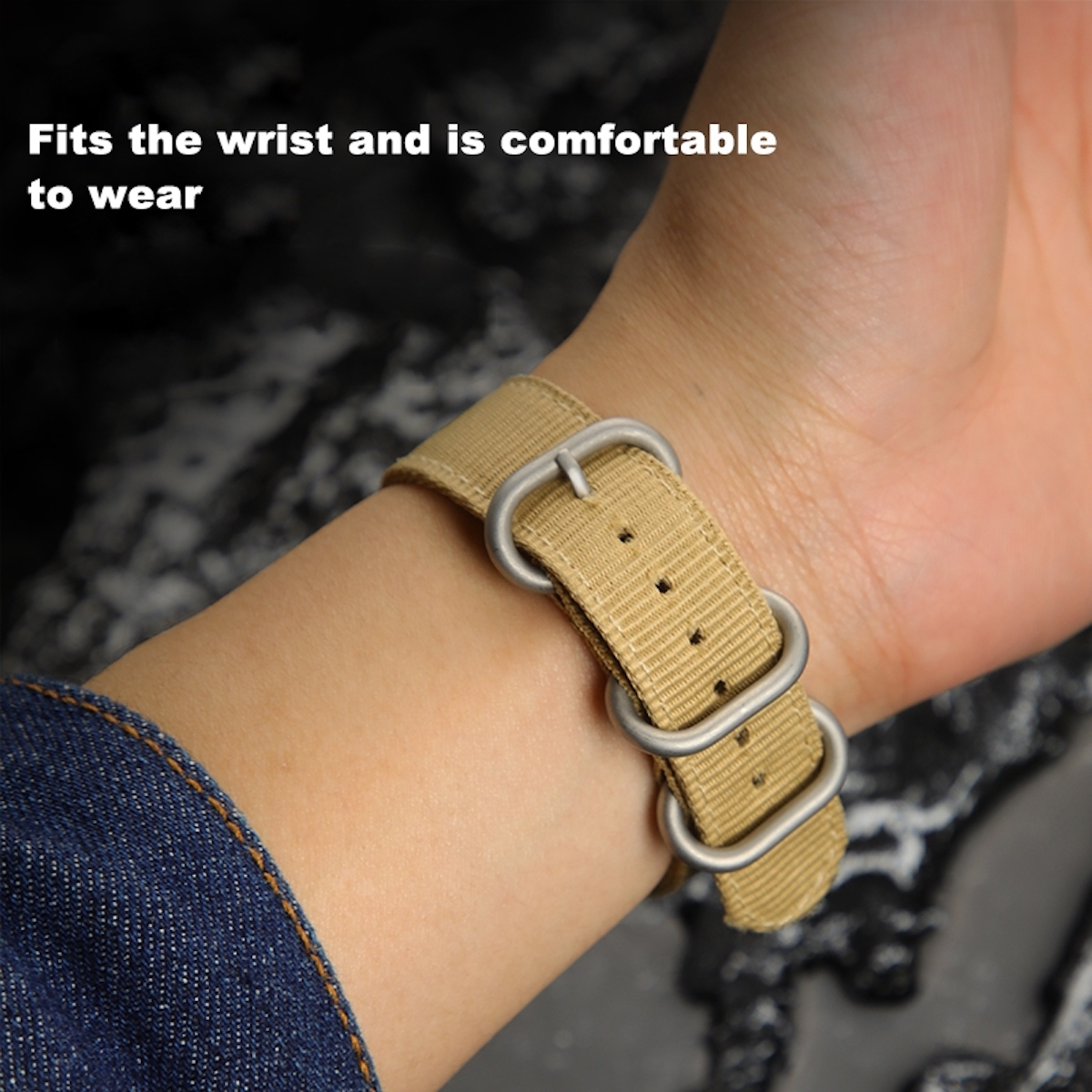 Nahaufnahme eines beigen Uhrenarmbands am Handgelenk. Das Armband hat silberne Schnallen.