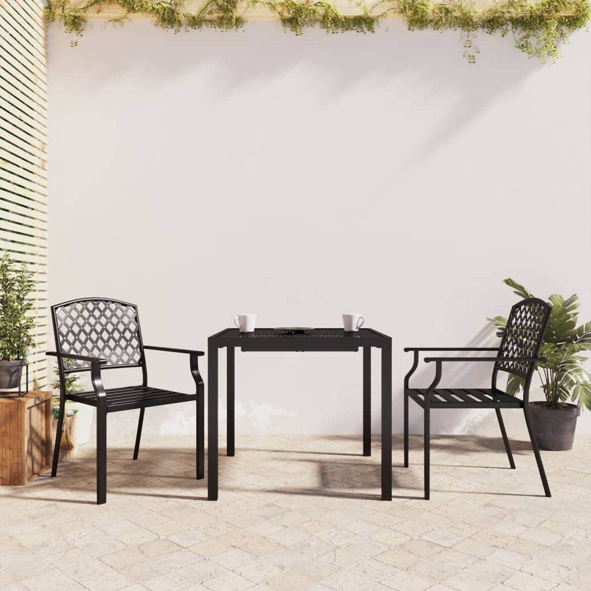 Schwarzes Ess-Set für draußen: Tisch und zwei Stühle auf einer Terrasse. Hintergrund: weiße Wand, Pflanzen.