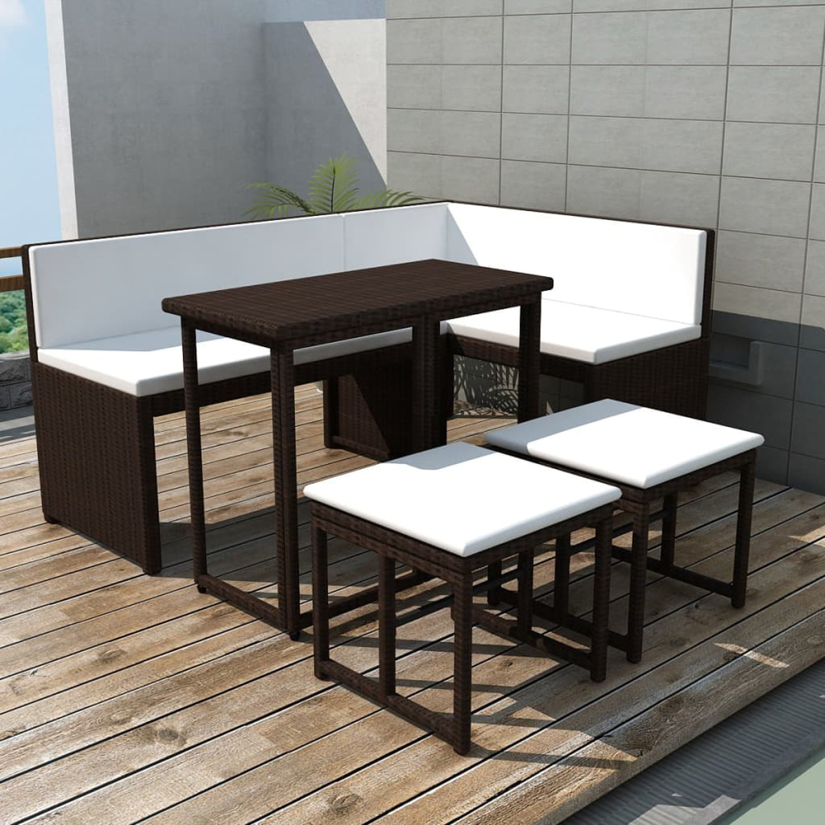 Outdoor-Sitzgruppe mit Tisch und zwei Bänken auf einem Holzdeck, mit weißen Kissen.