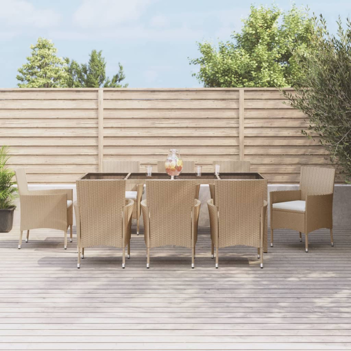 Ein Esszimmer-Set im Freien auf einer Holzterrasse mit Tisch, Stühlen und Gläsern. Sonniger Tag mit Bäumen.