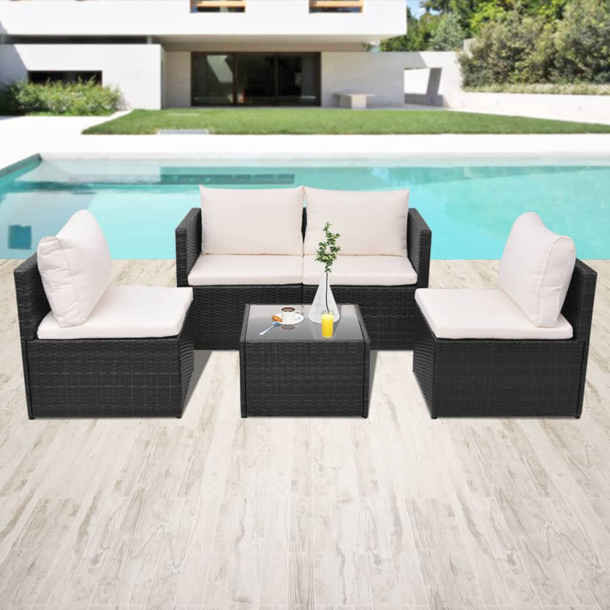 Schwarzes Rattan-Gartenset mit weißen Kissen um einen schwarzen Couchtisch.