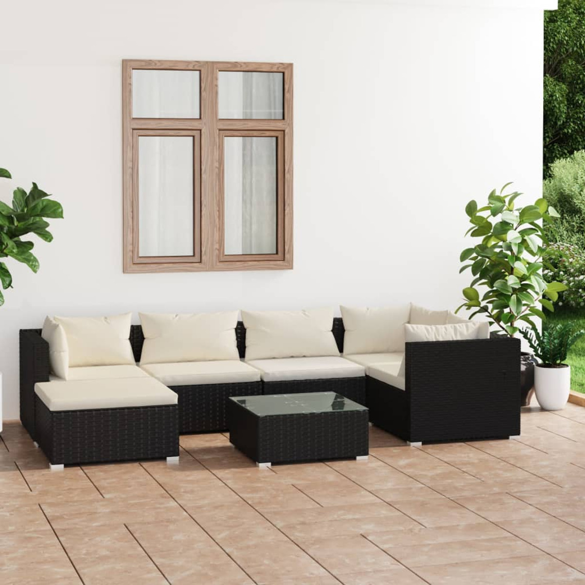 Schwarzes Outdoor-Sofa mit cremefarbenen Kissen und Glastisch.