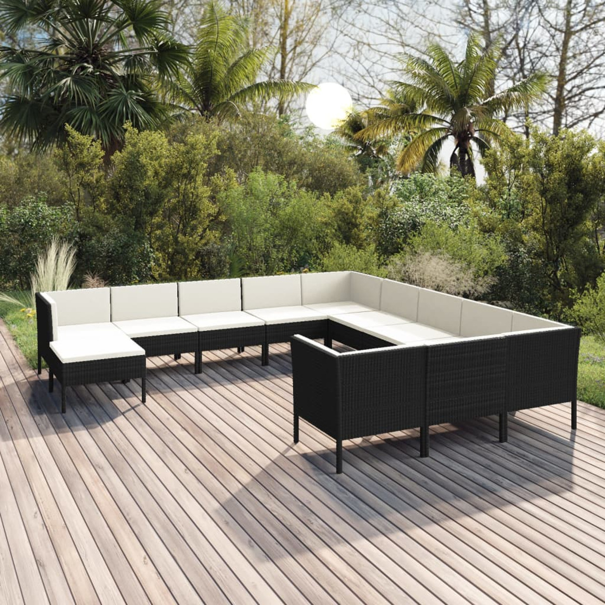 Große Sitzgruppe im Freien mit schwarzen Rattansofas, weißen Kissen und Holzterrasse im Hintergrund.